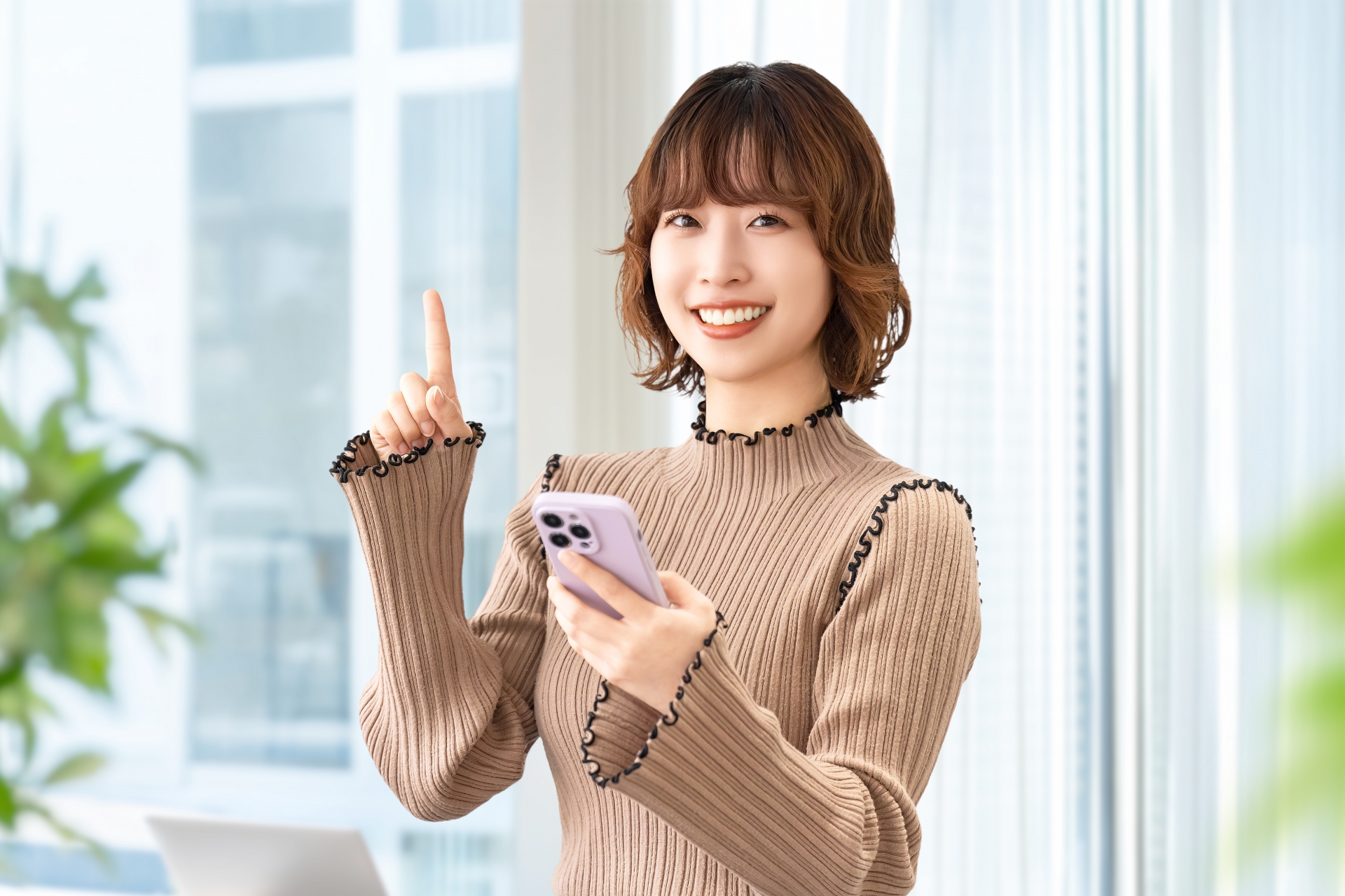 スマホを持って案内をする笑顔の女性