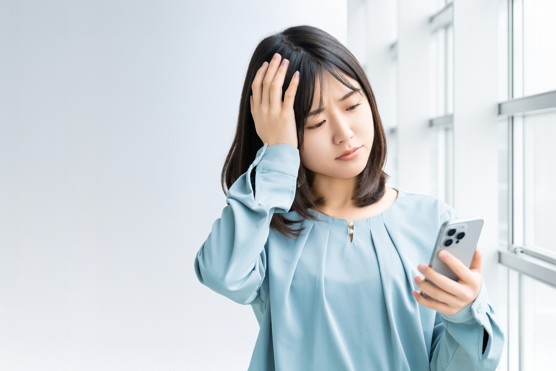 スマホを見て考える女性