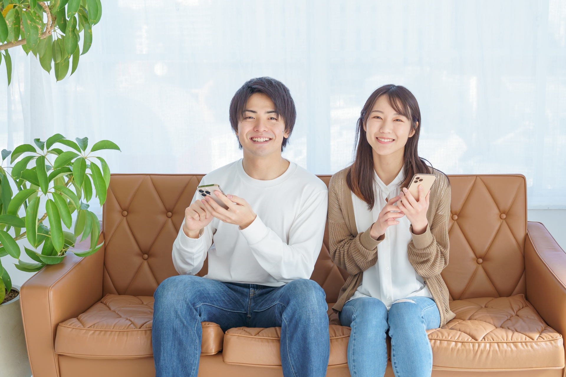 スマホを手に持つ笑顔の夫婦