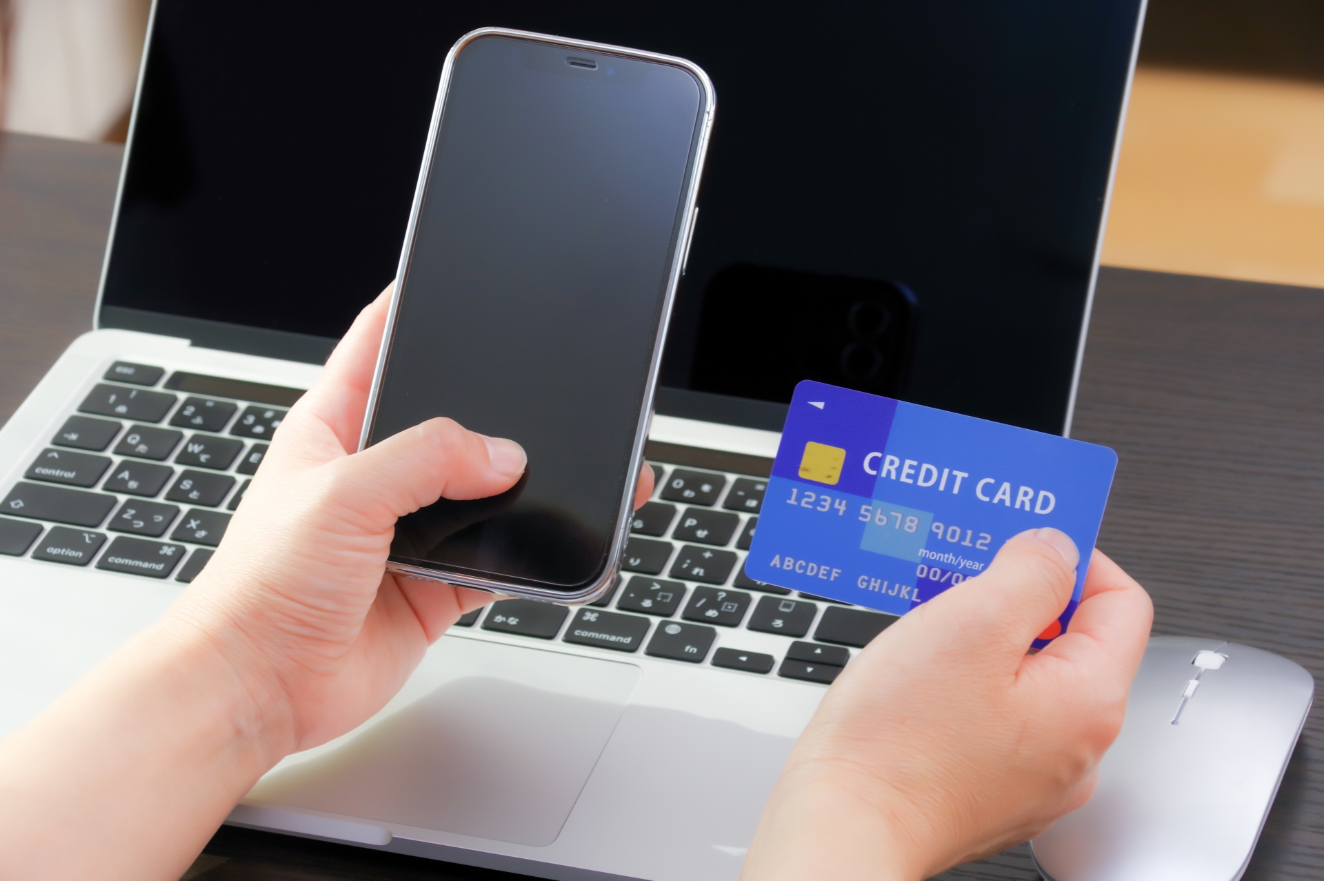 スマホとクレジットカードを持つ女性