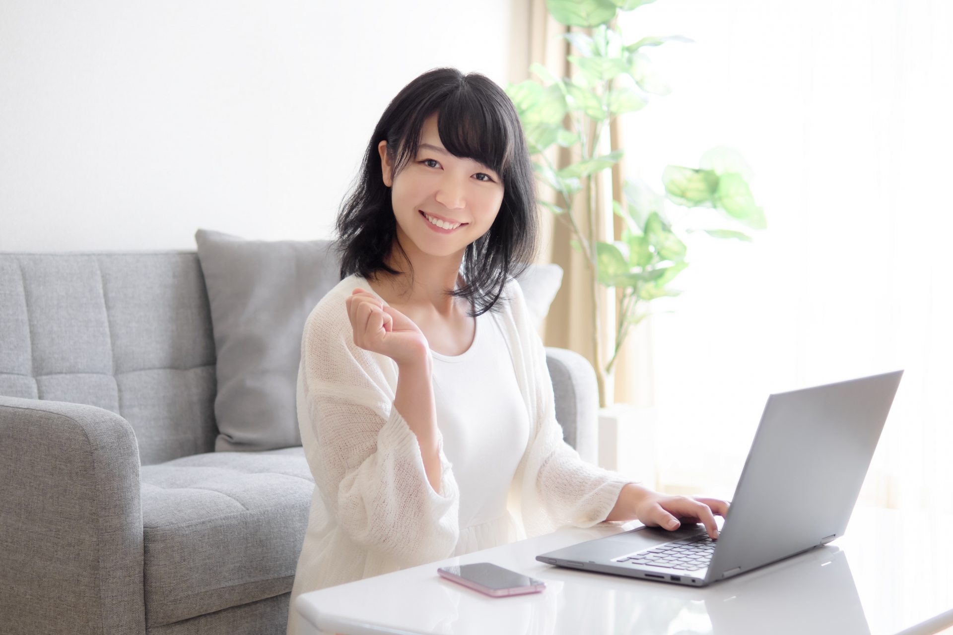 スマホとパソコンを操作する若い女性