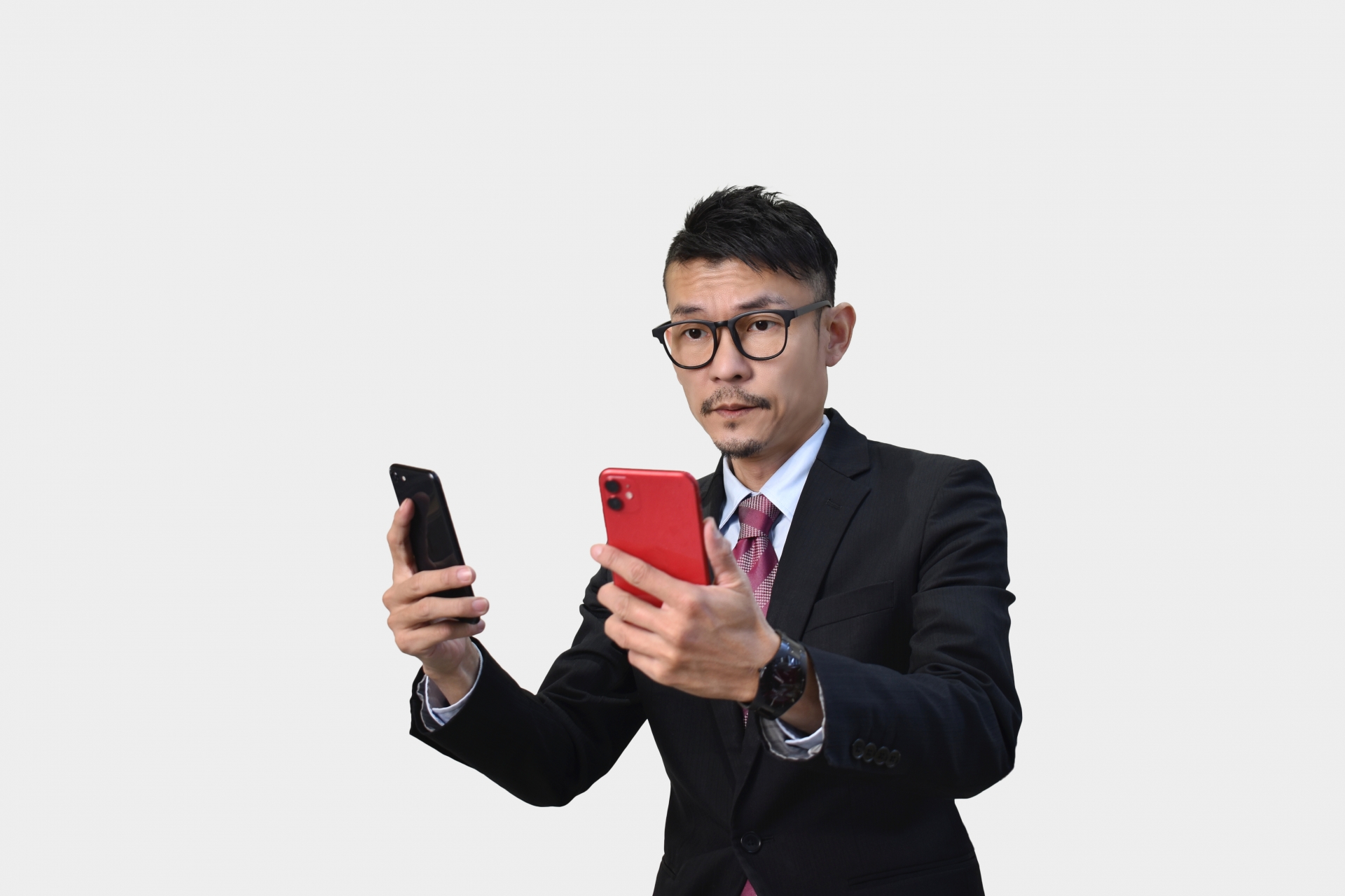 両手にスマホを持つ男性