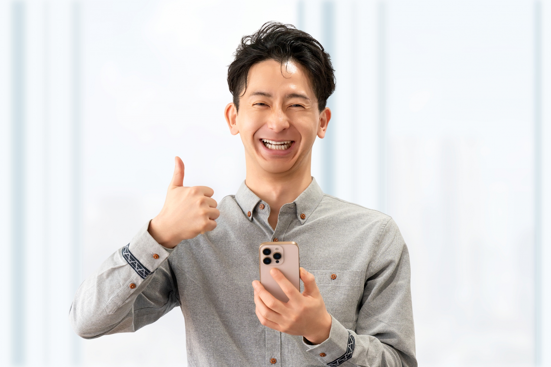 スマホを持っていいね！のポーズをする男性