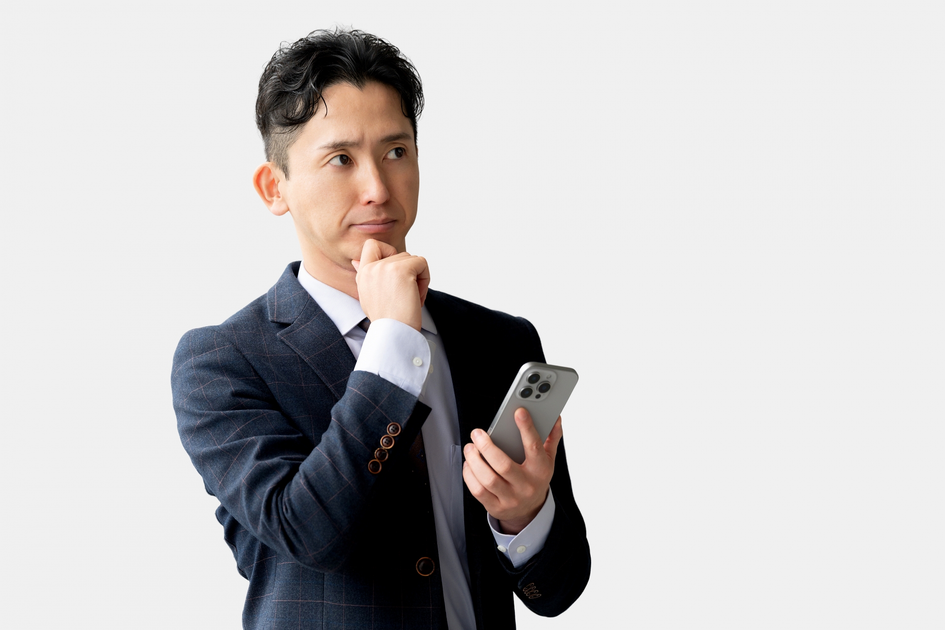 スマホを見て考える男性ビジネスマン