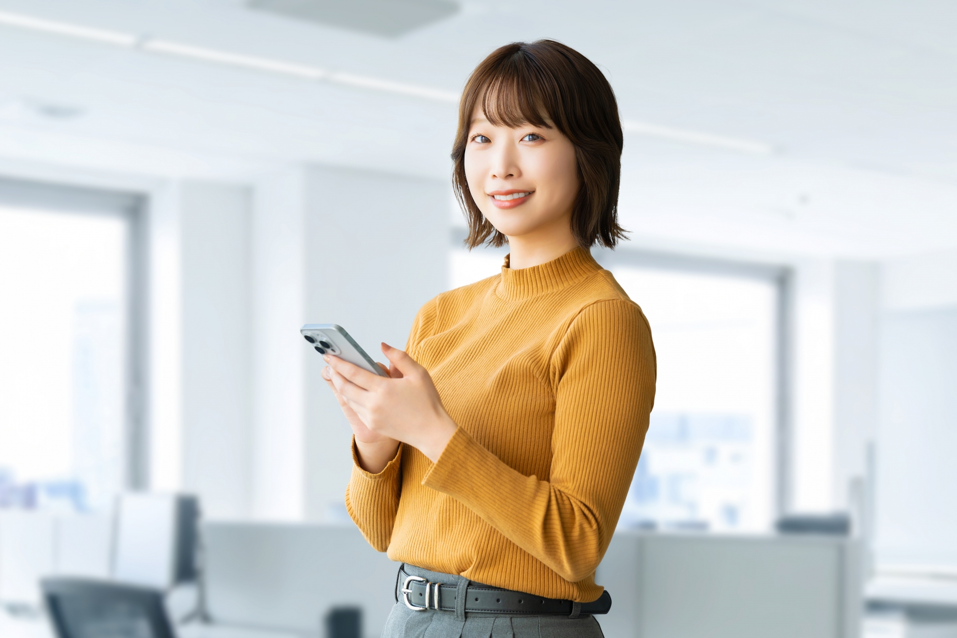 スマホを使う笑顔の女性・ビジネスウーマン