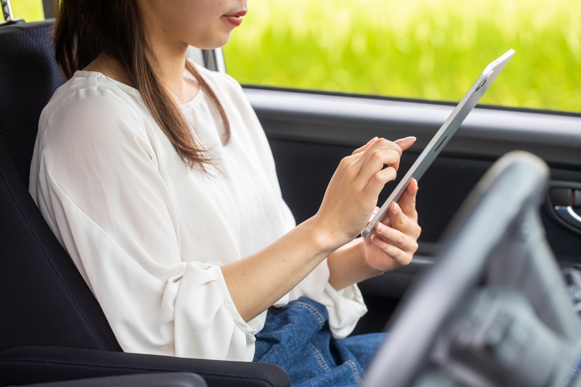 助手席で調べ物をする女性