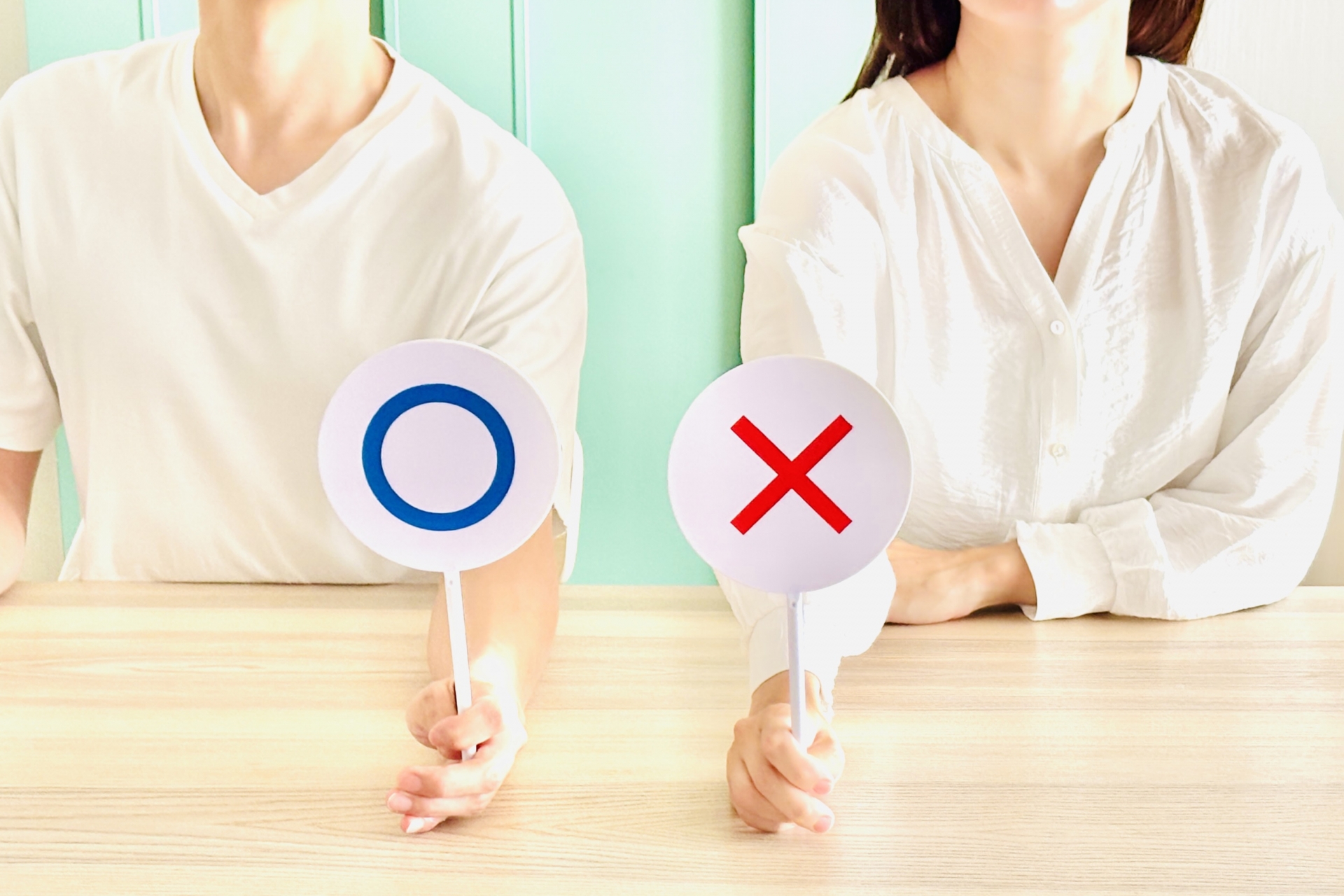 丸バツプレートを持つ男女