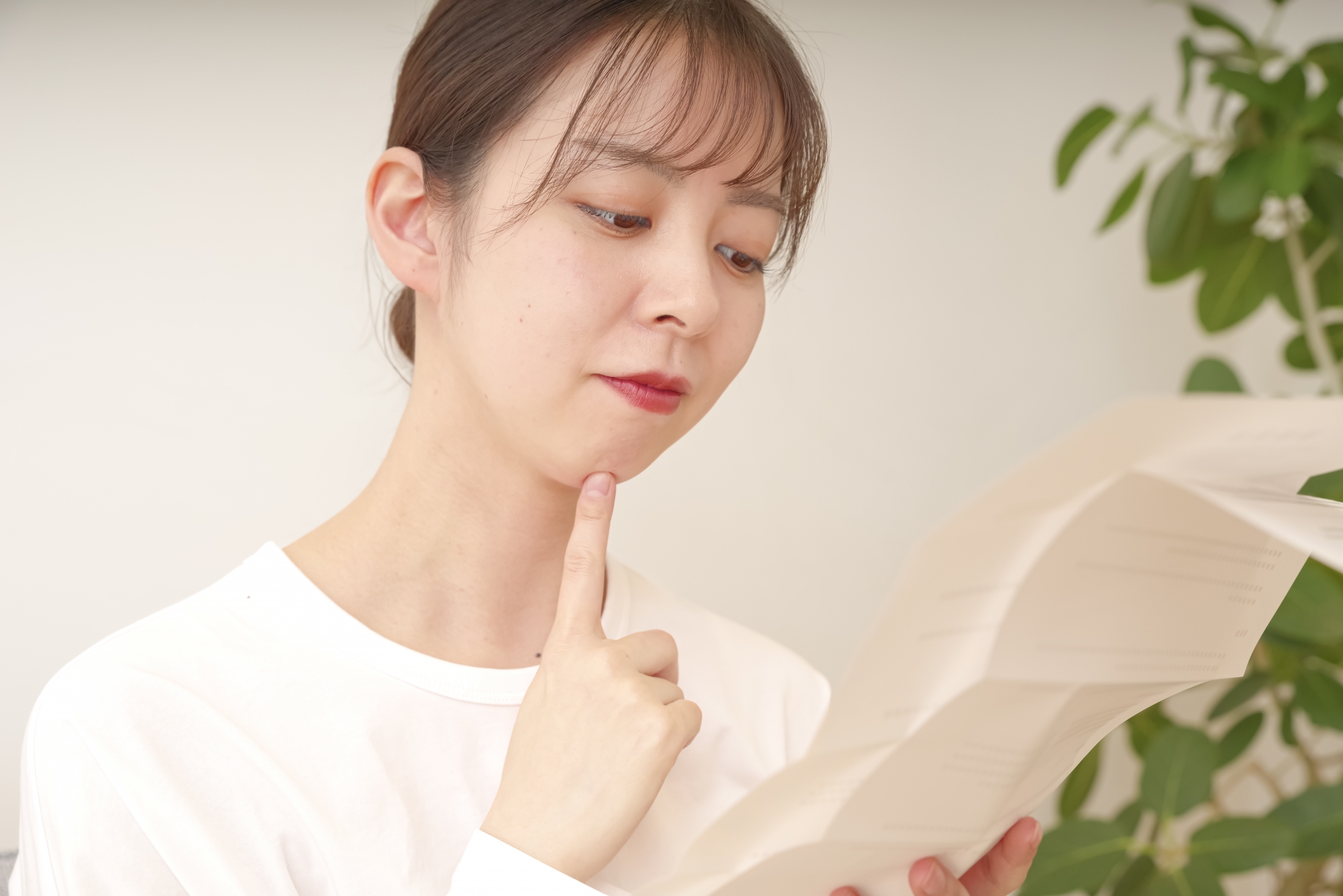 書類を見て複雑な表情をする女性