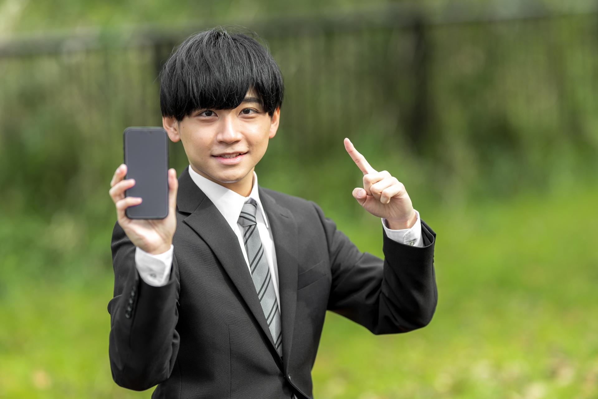 スマホを持っているスーツ姿の男性