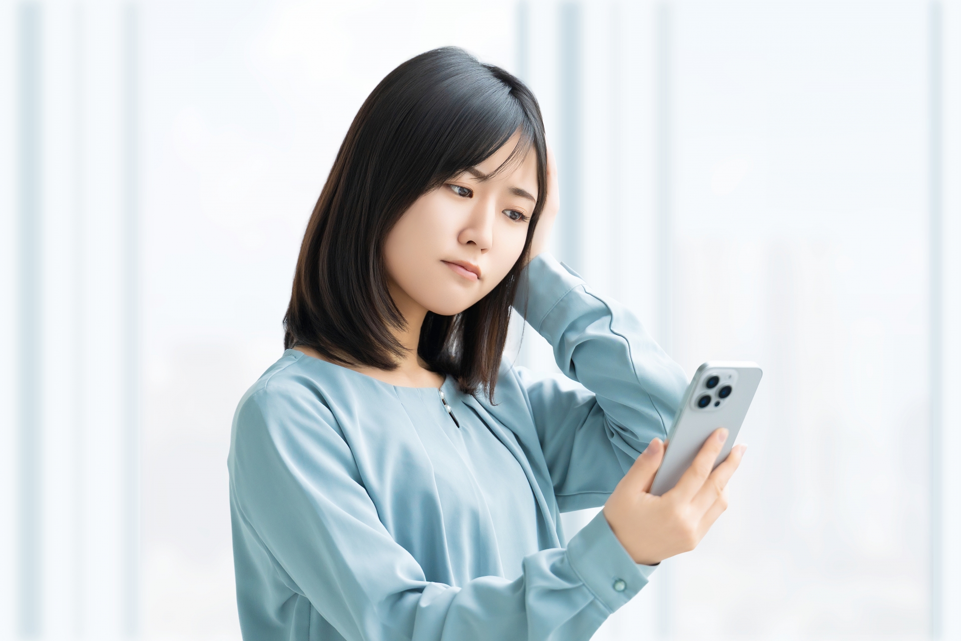 スマホを見て考える女性・ビジネスウーマン