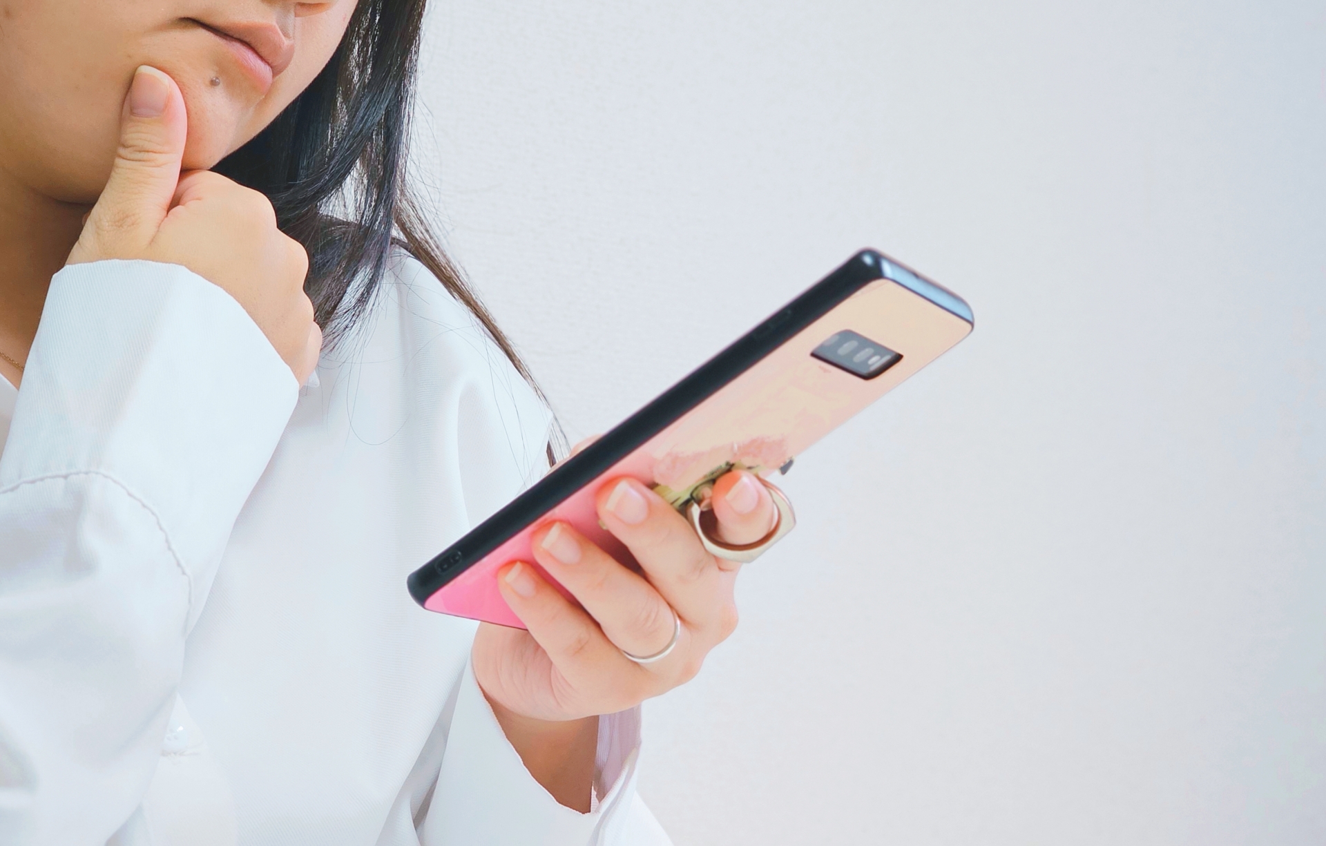 スマホを見て悩んでいる女性