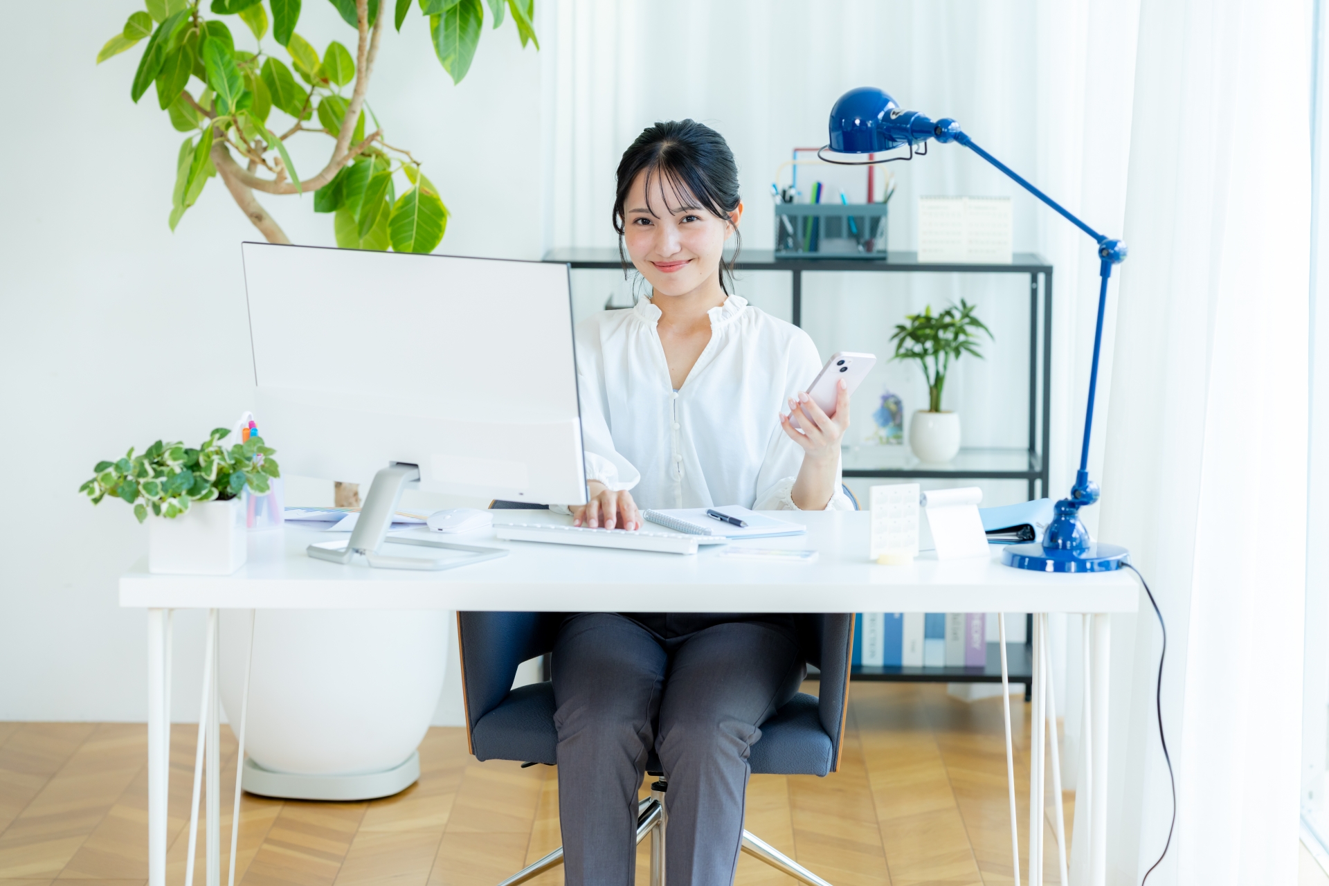 オフィスでスマホを持つビジネスウーマン