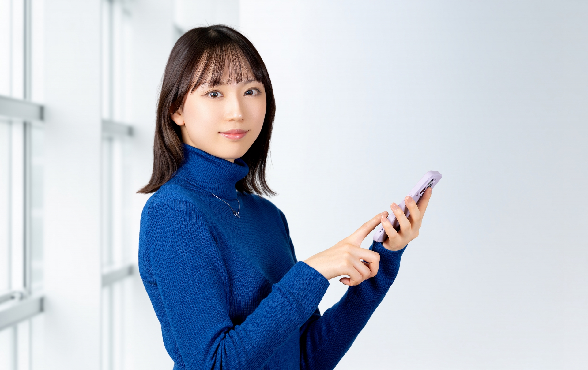 スマホを持つ笑顔の女性・ビジネスウーマン