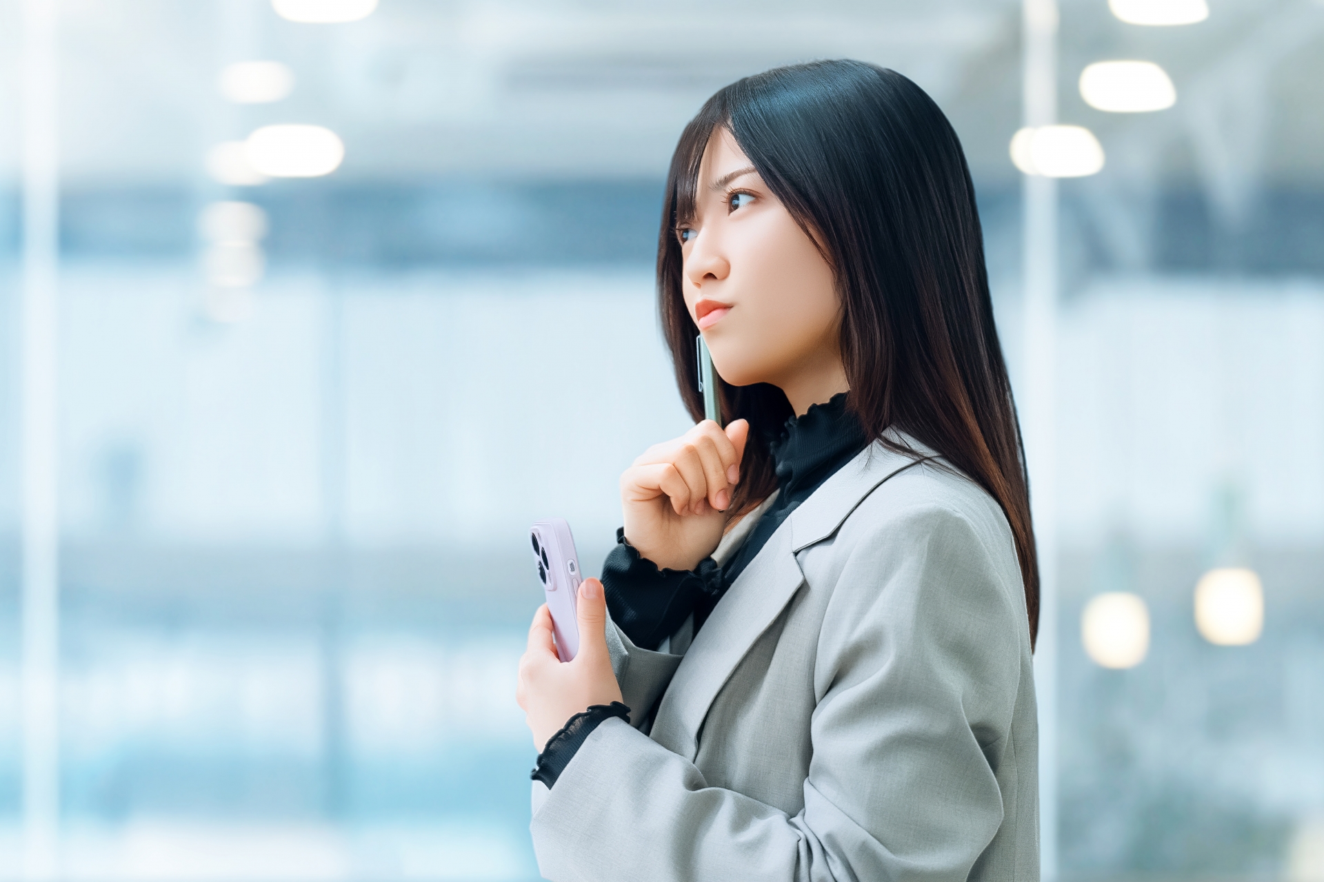 スマホを持って考える女性