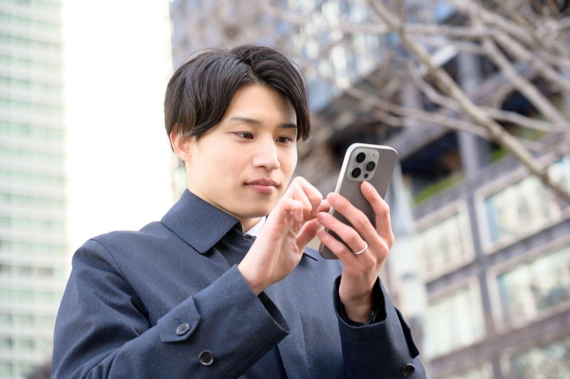 外でスマホを操作する男性