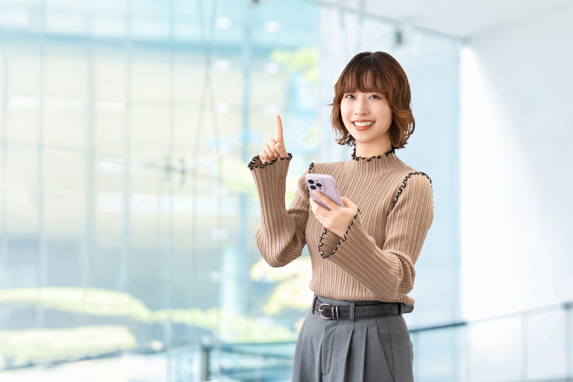 スマホを持って案内をする笑顔の女性
