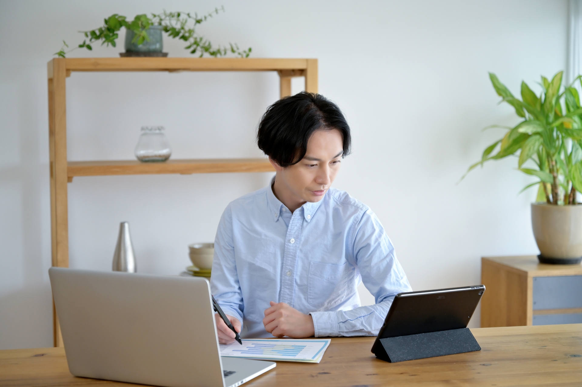 パソコンとタブレットを同時に使用する男性