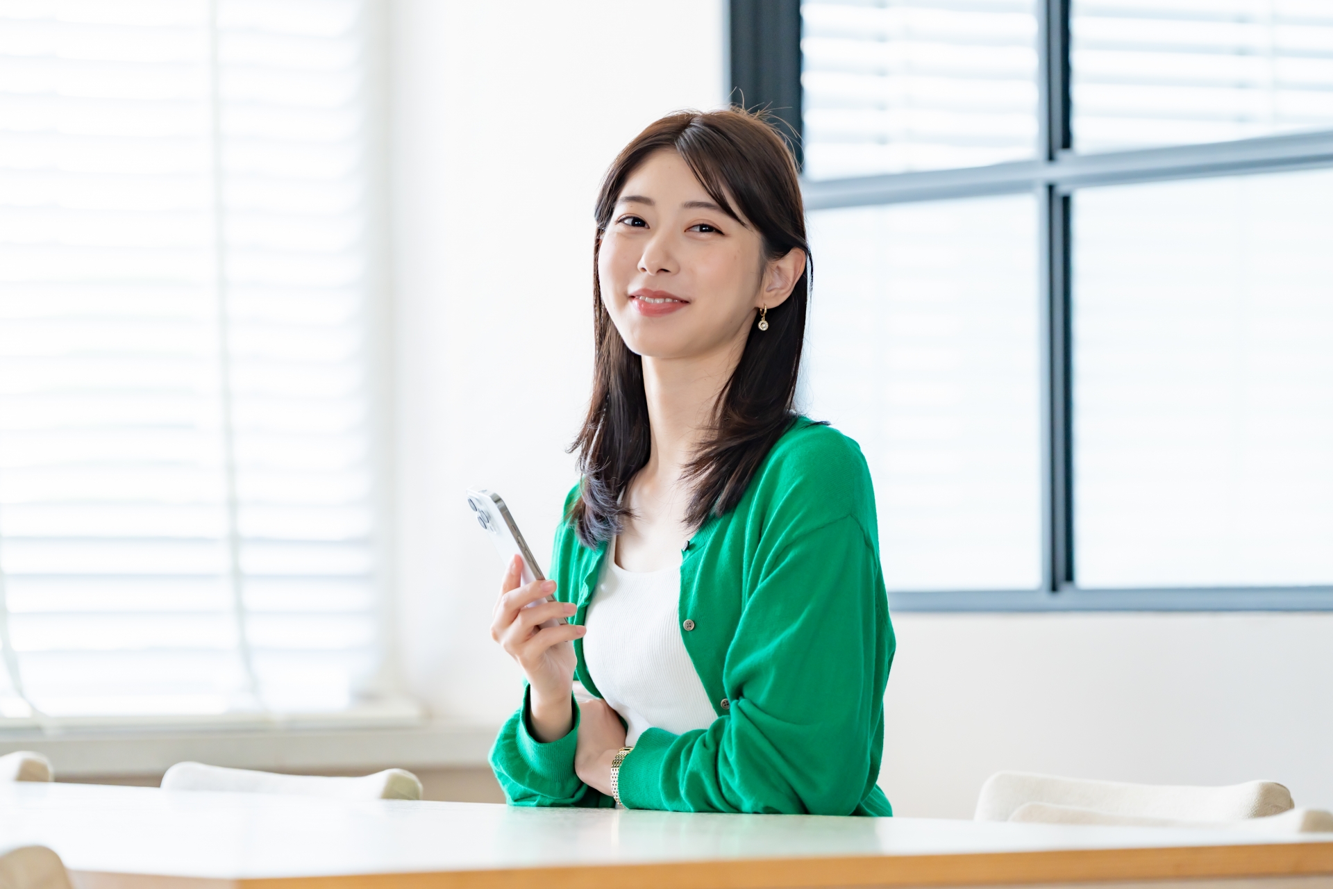 スマートフォンを持ち微笑む女性