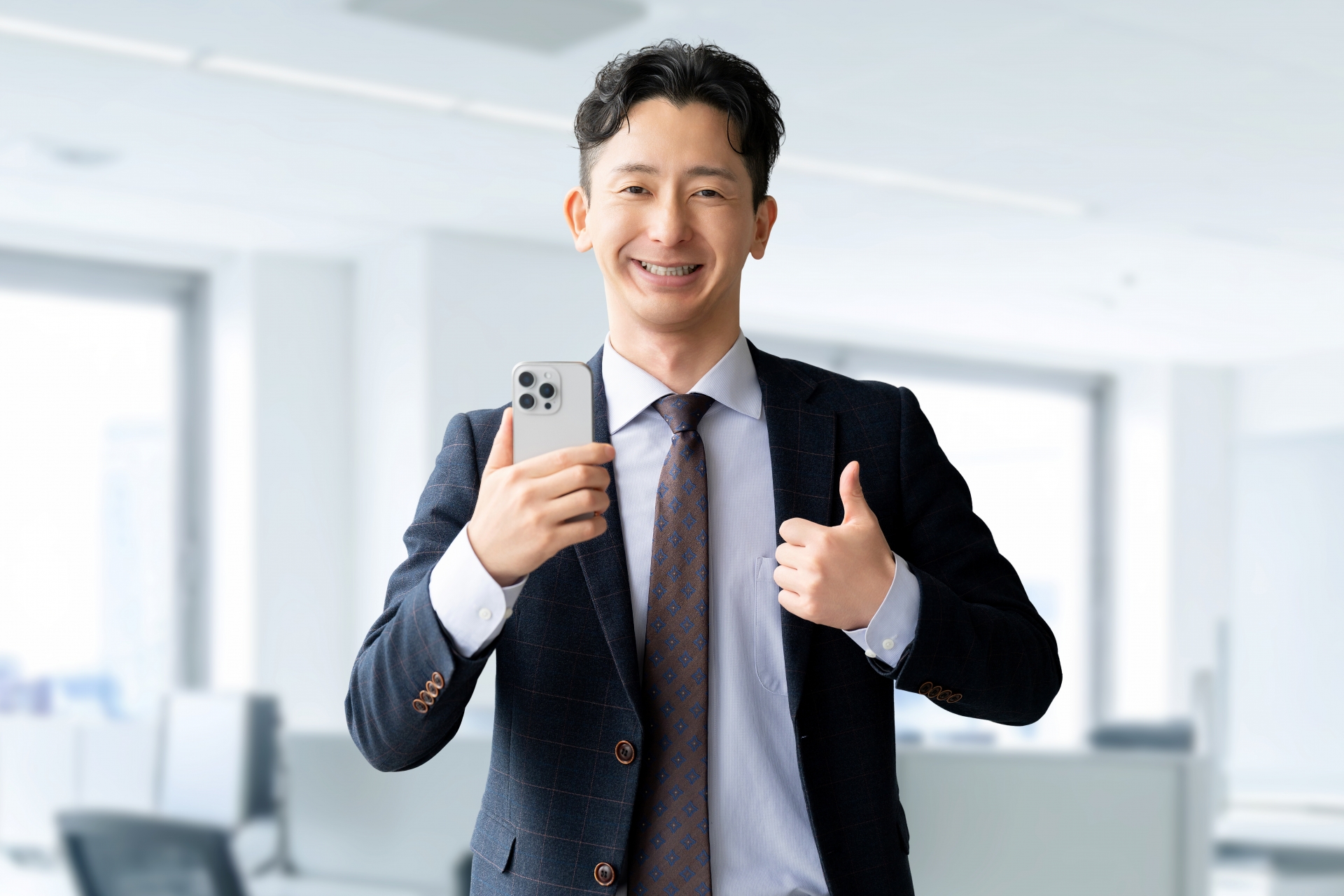 スマホを持っていいね！のポーズをする男性