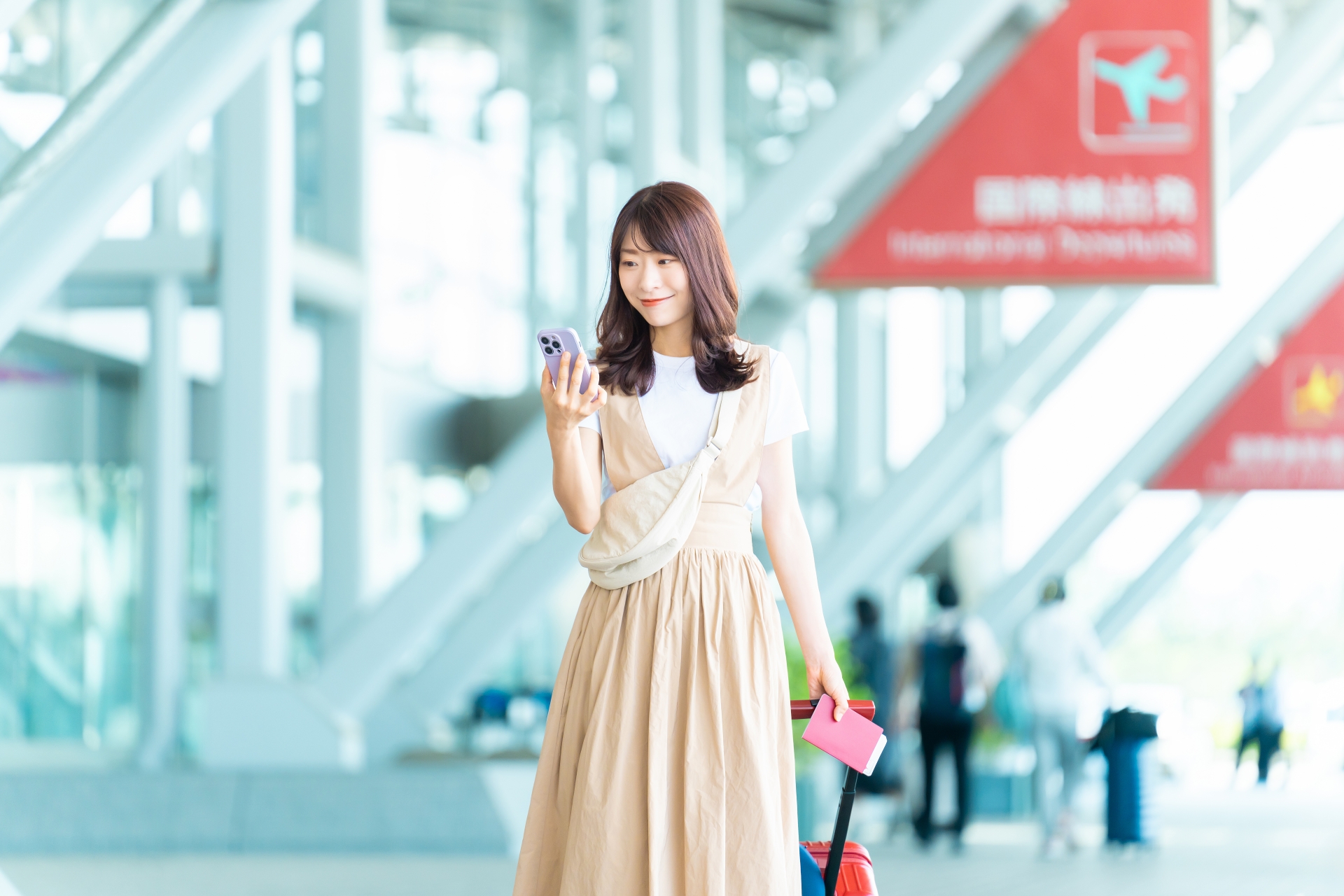 空港でスマホを持つ女性
