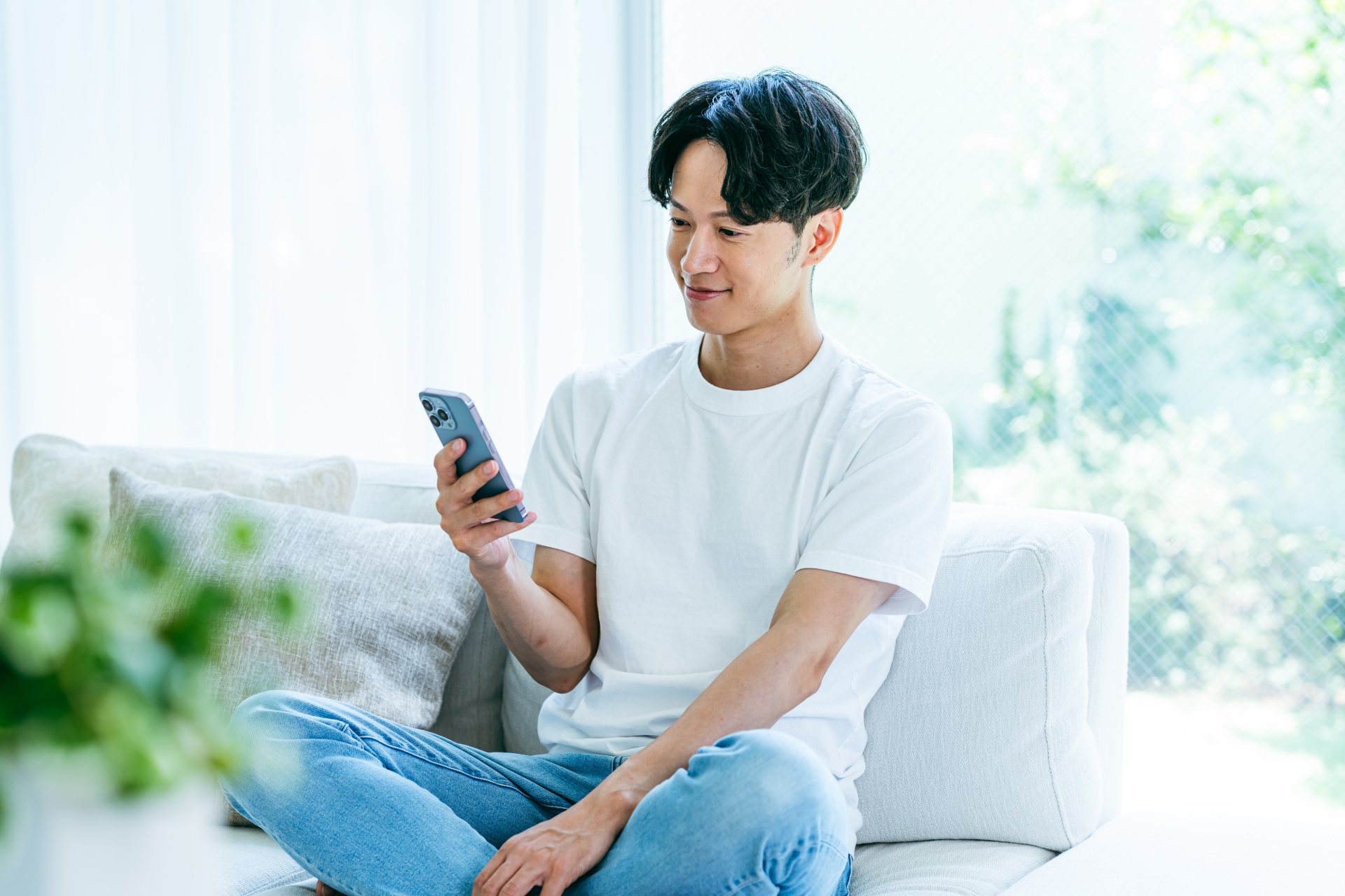 ソファでスマホを見る男性