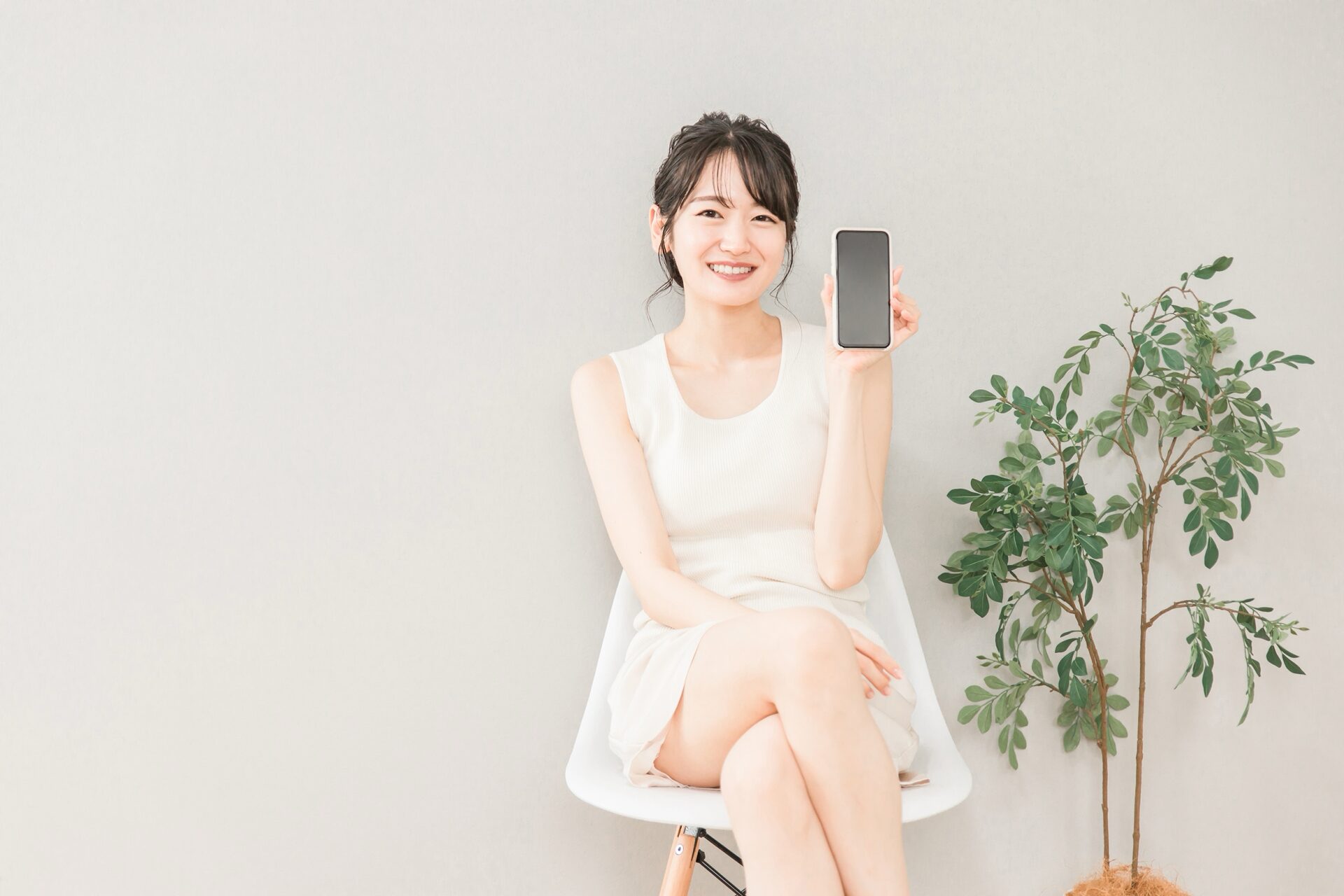 スマホの画面を見せる女性