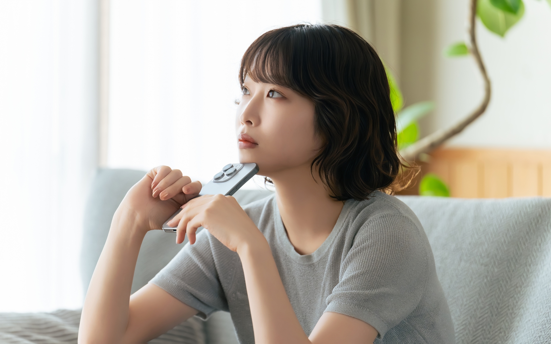 スマホを持って考える女性