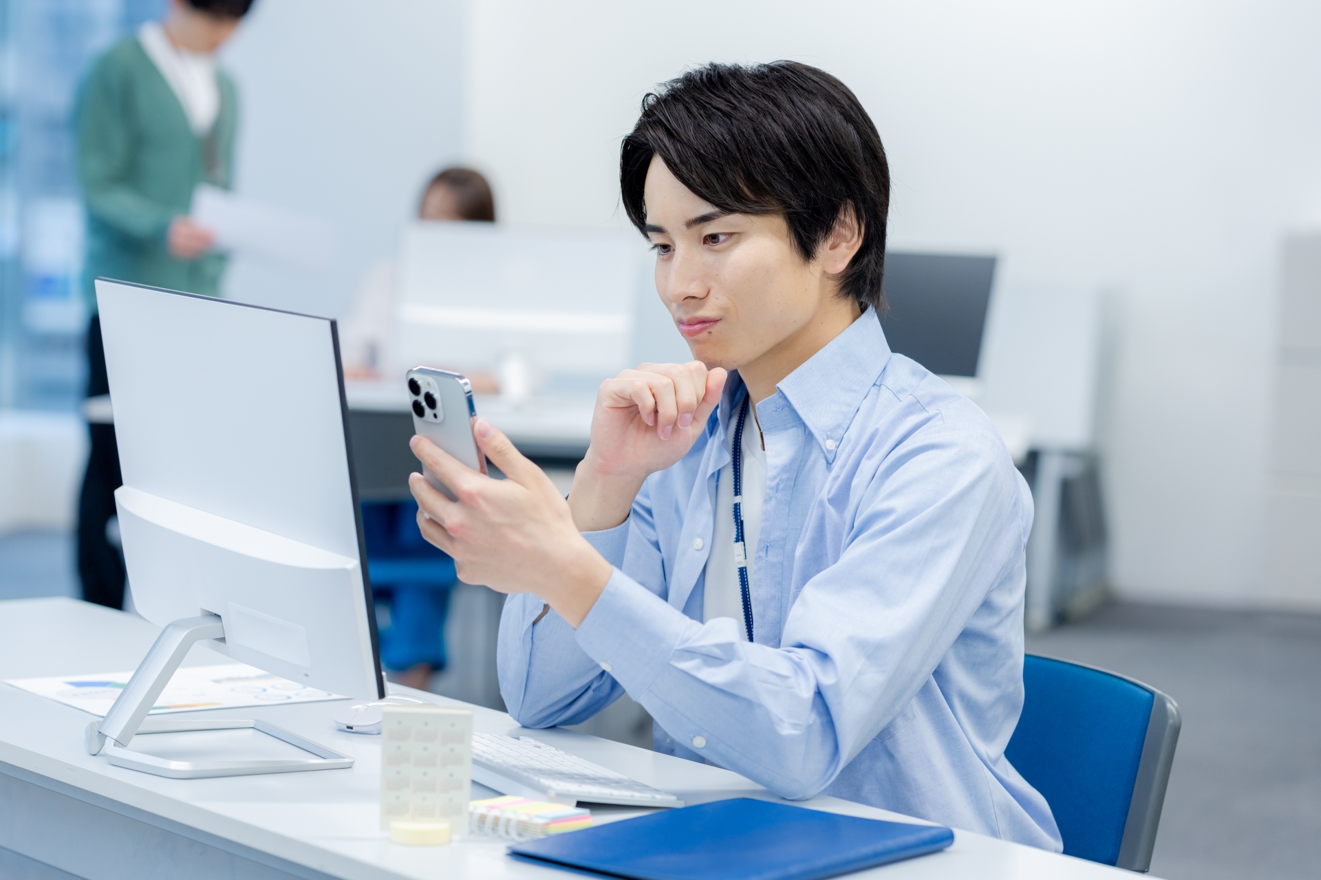 オフィスでスマホを使うビジネスマン