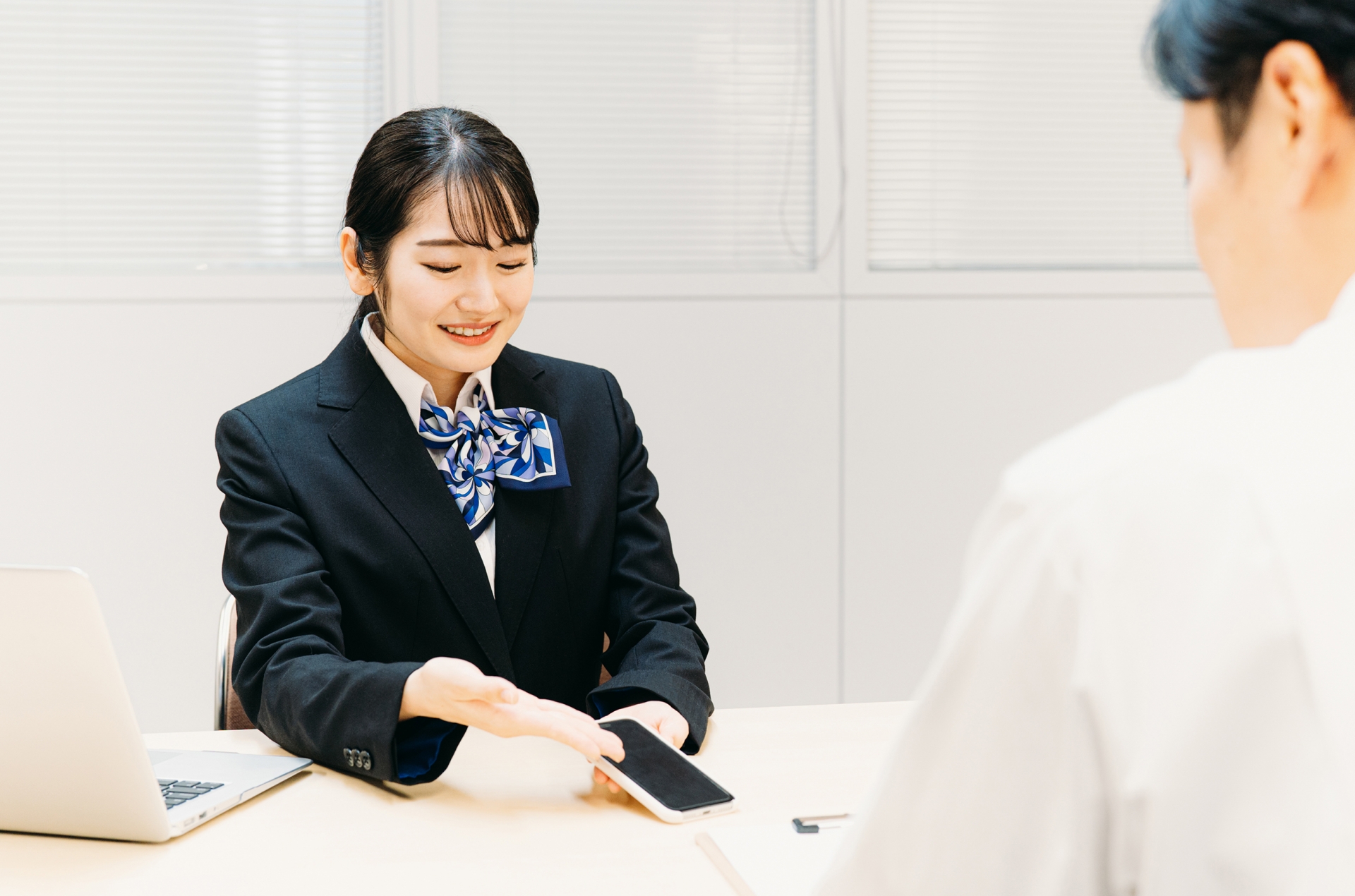 スマホの説明をする女性（携帯ショップ）