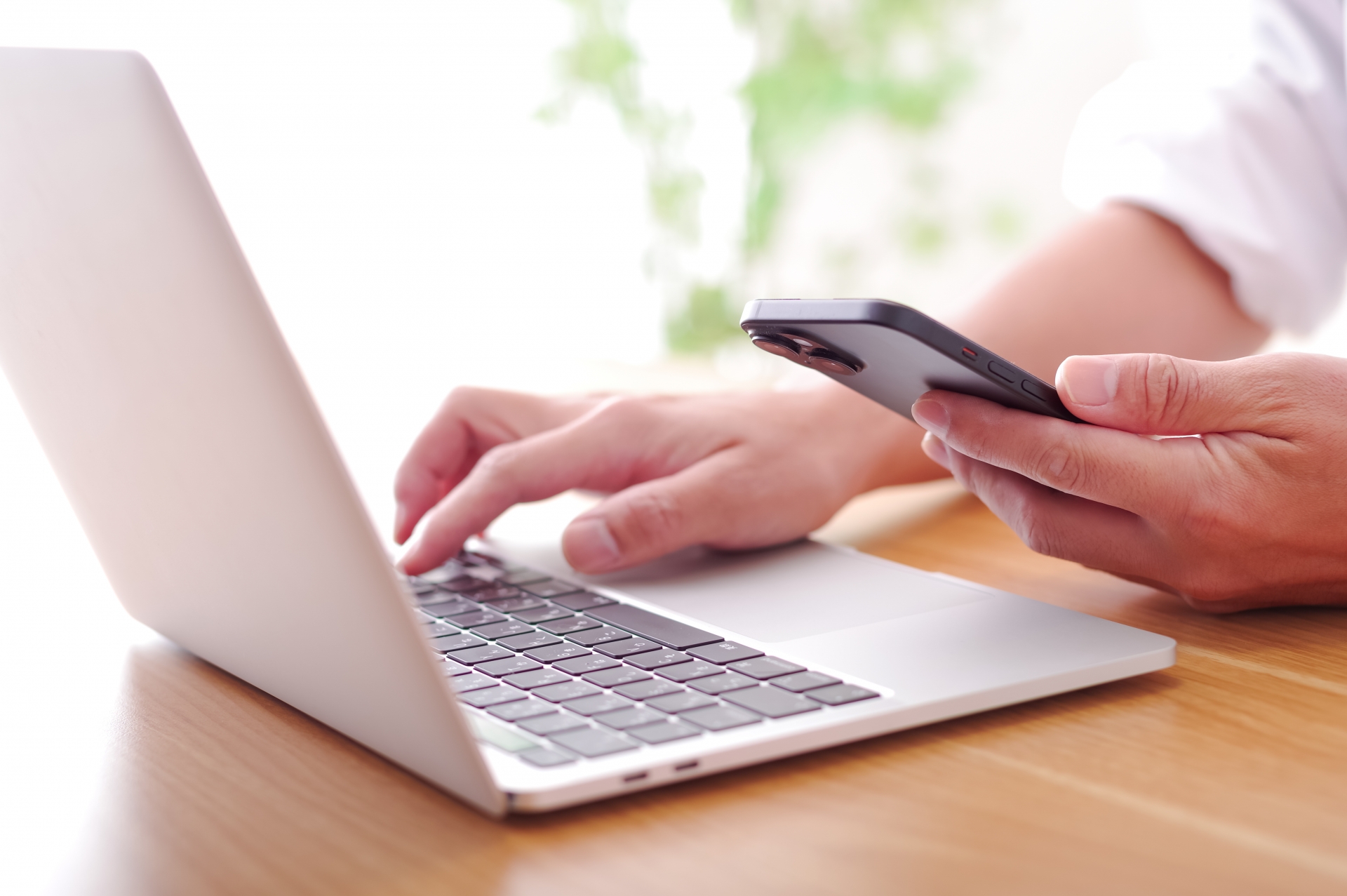 パソコンとスマホを操作する男性