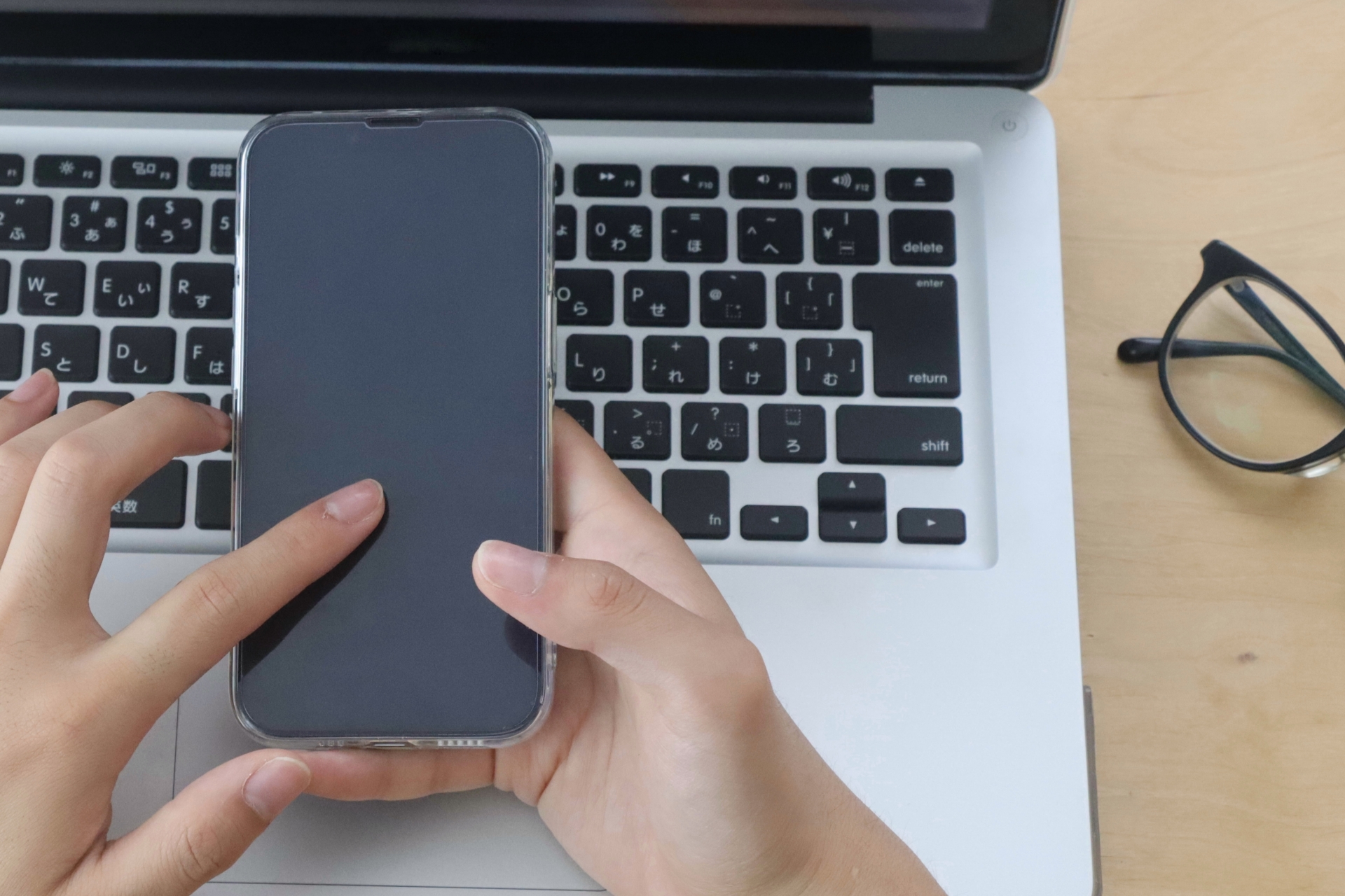 スマホを指さす男性の手