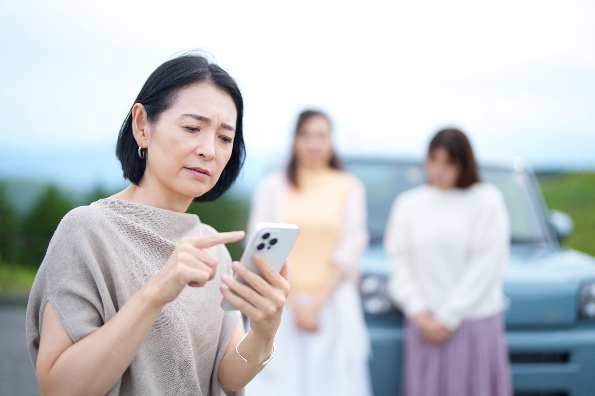 困った顔でスマホを操作する女性