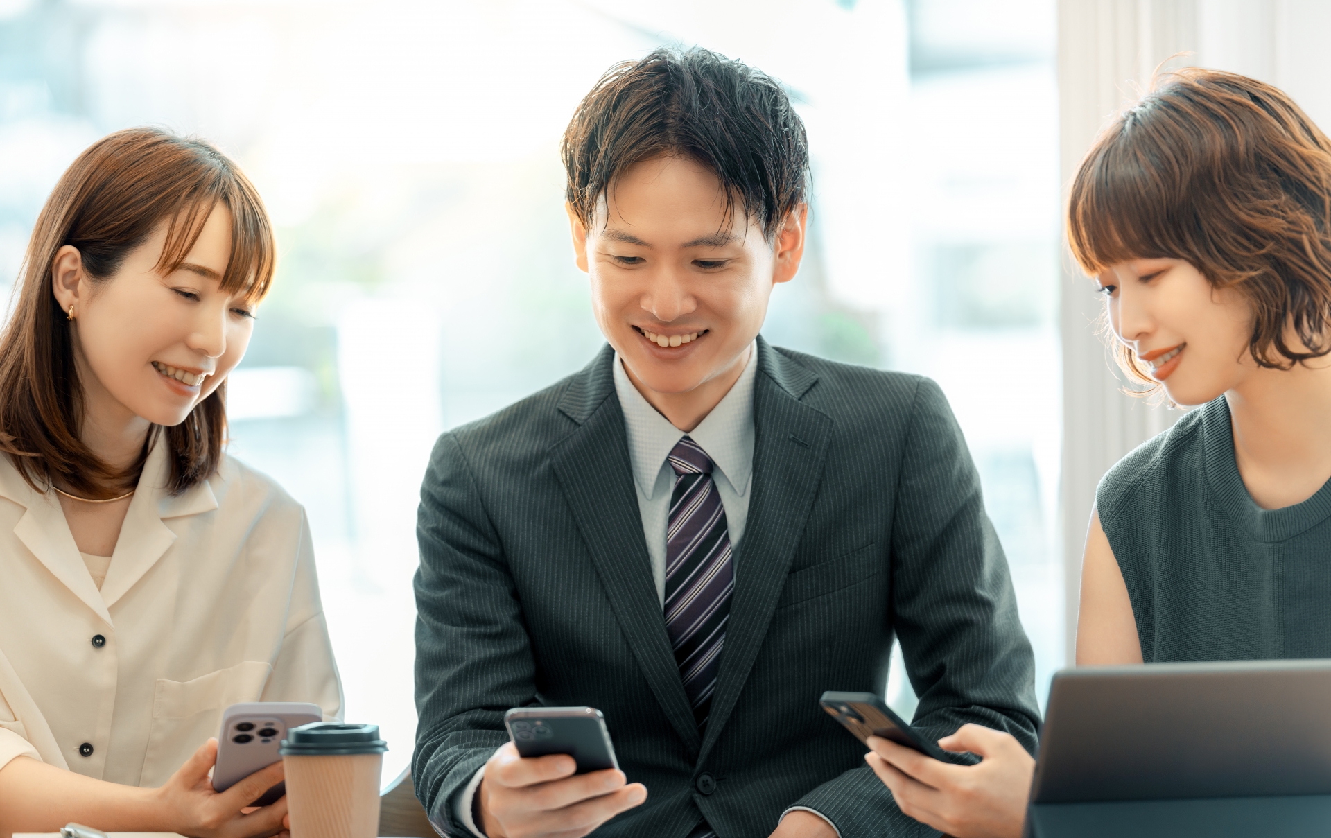 スマホを使う男女3人のビジネスマン