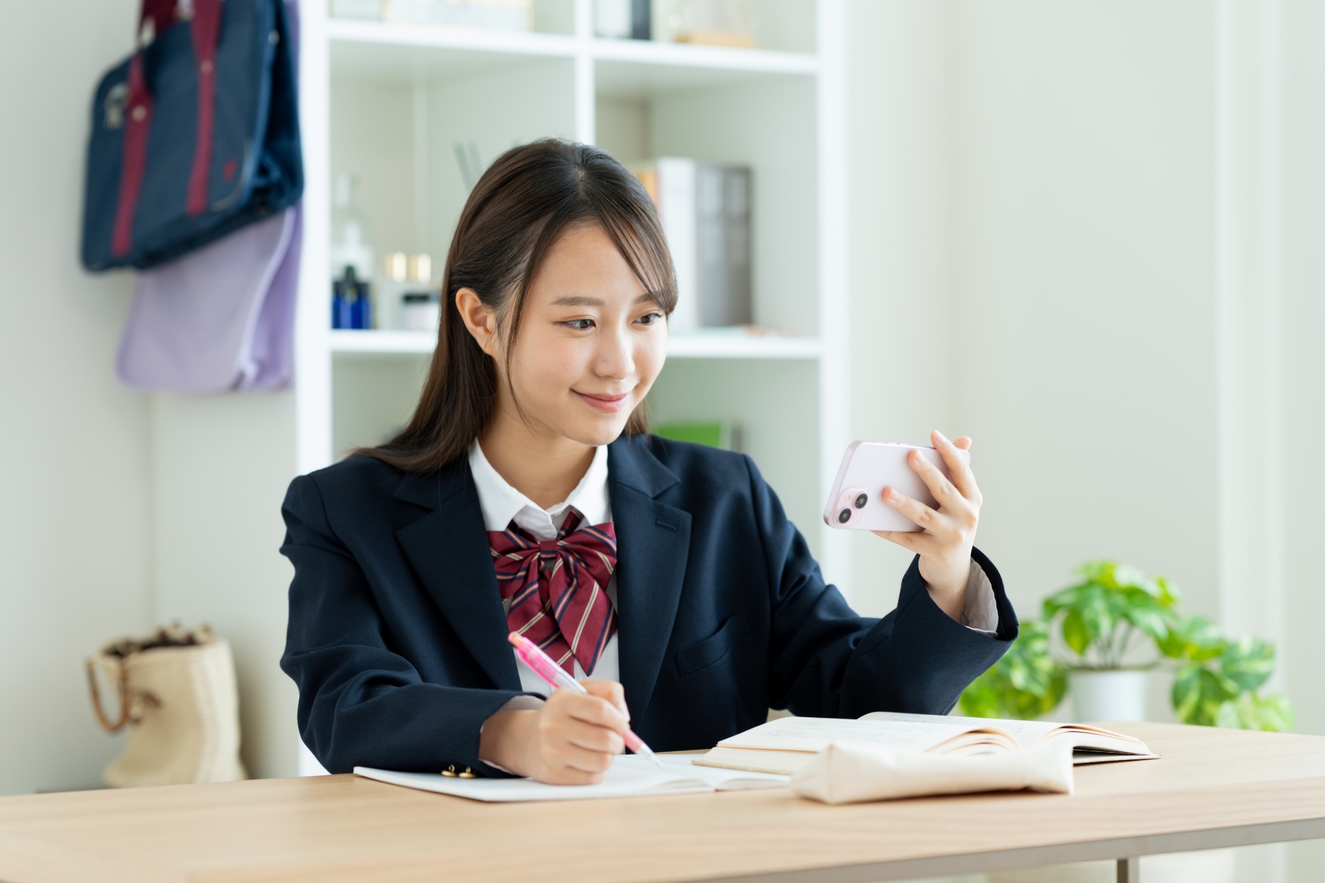 スマホのアプリで勉強する女子高生