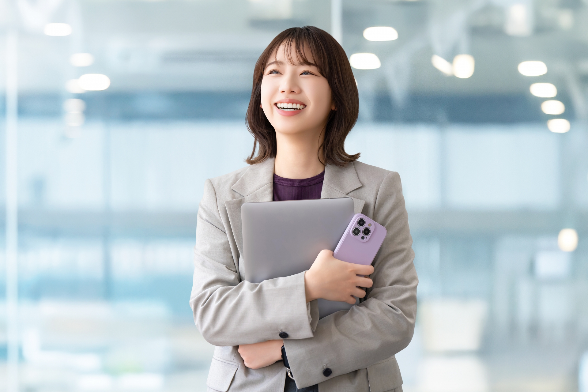 パソコンとスマホを持つ笑顔の女性