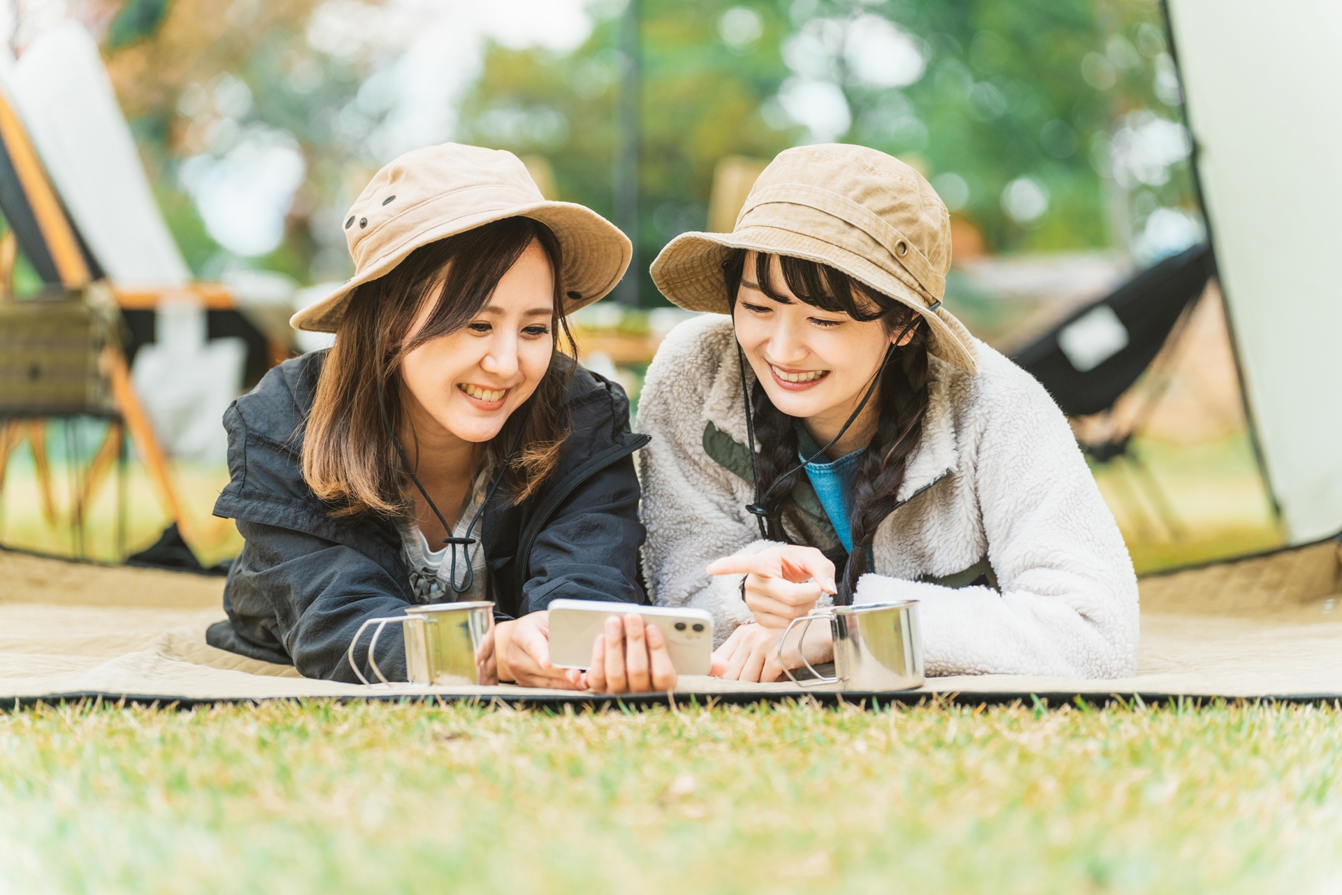 キャンプでスマホを使う女性