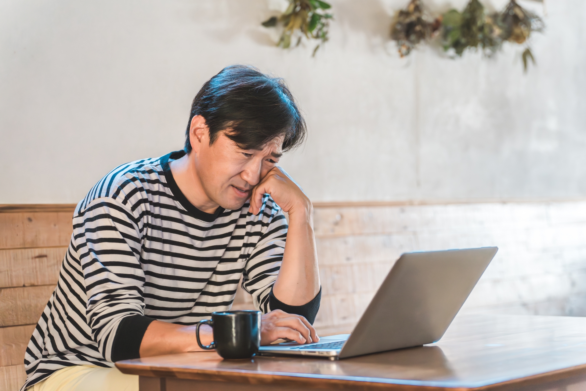 パソコンを見て落ち込む男性