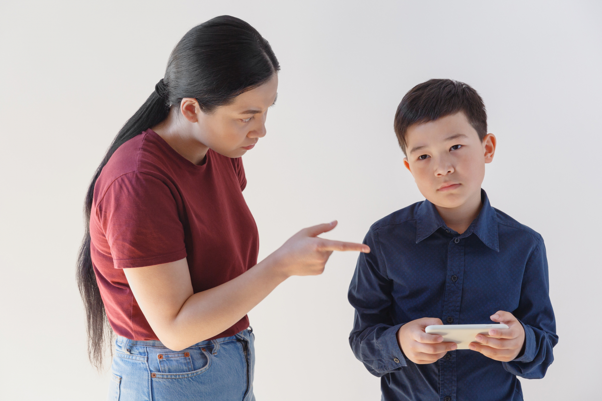母親に叱られるスマホを持った男の子