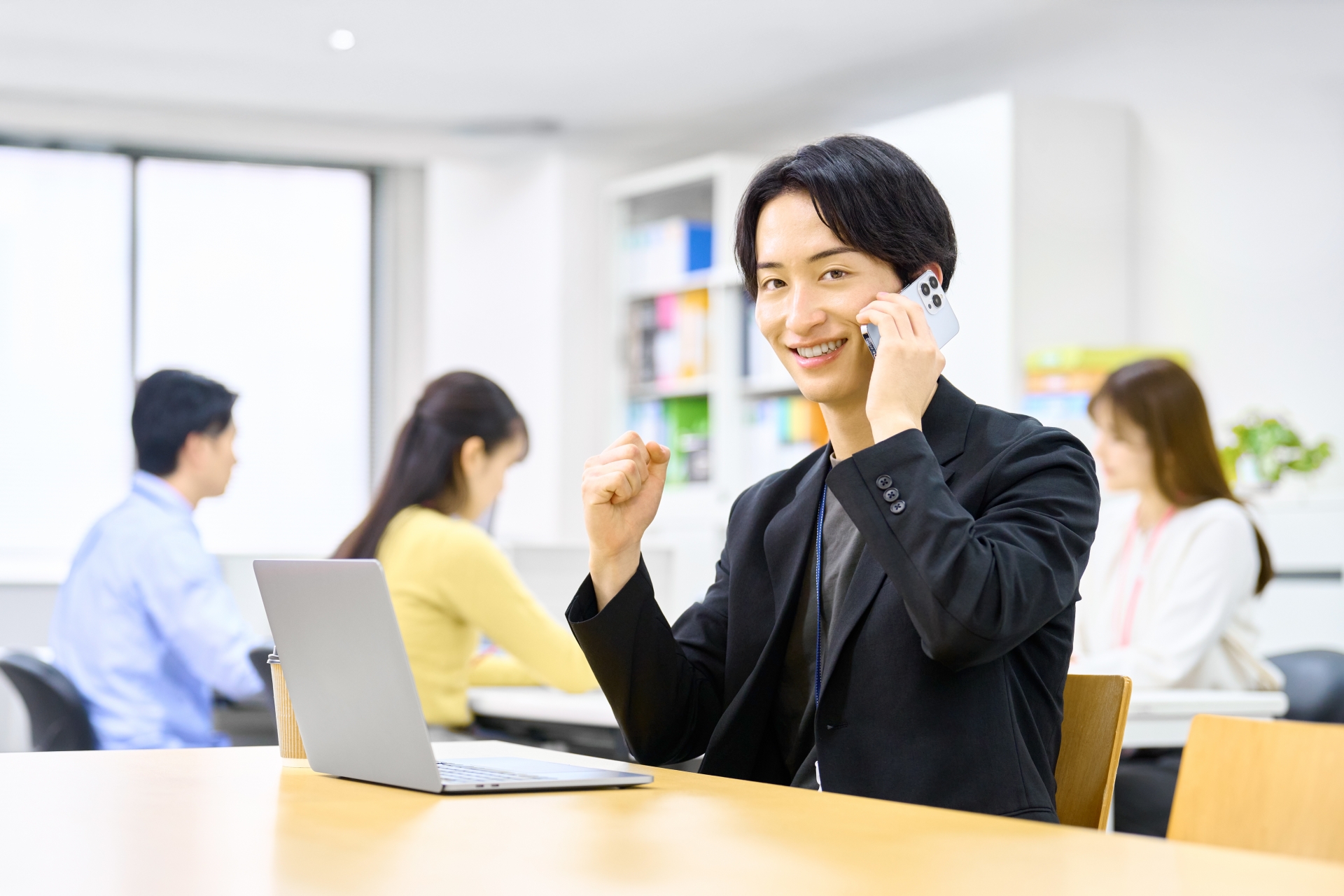 電話しながらガッツポーズするビジネスマン