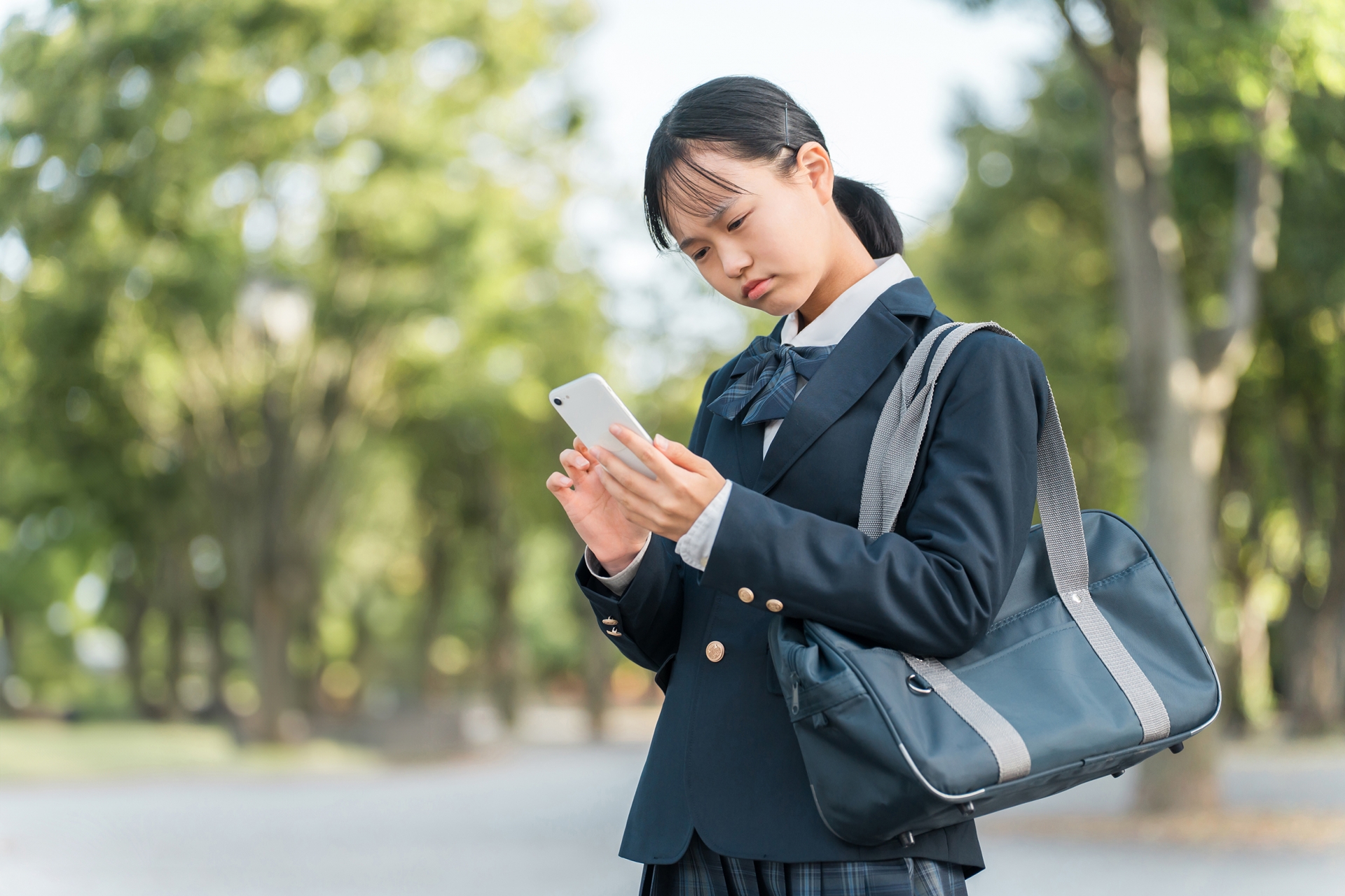 スマホを見ながら困る中学生