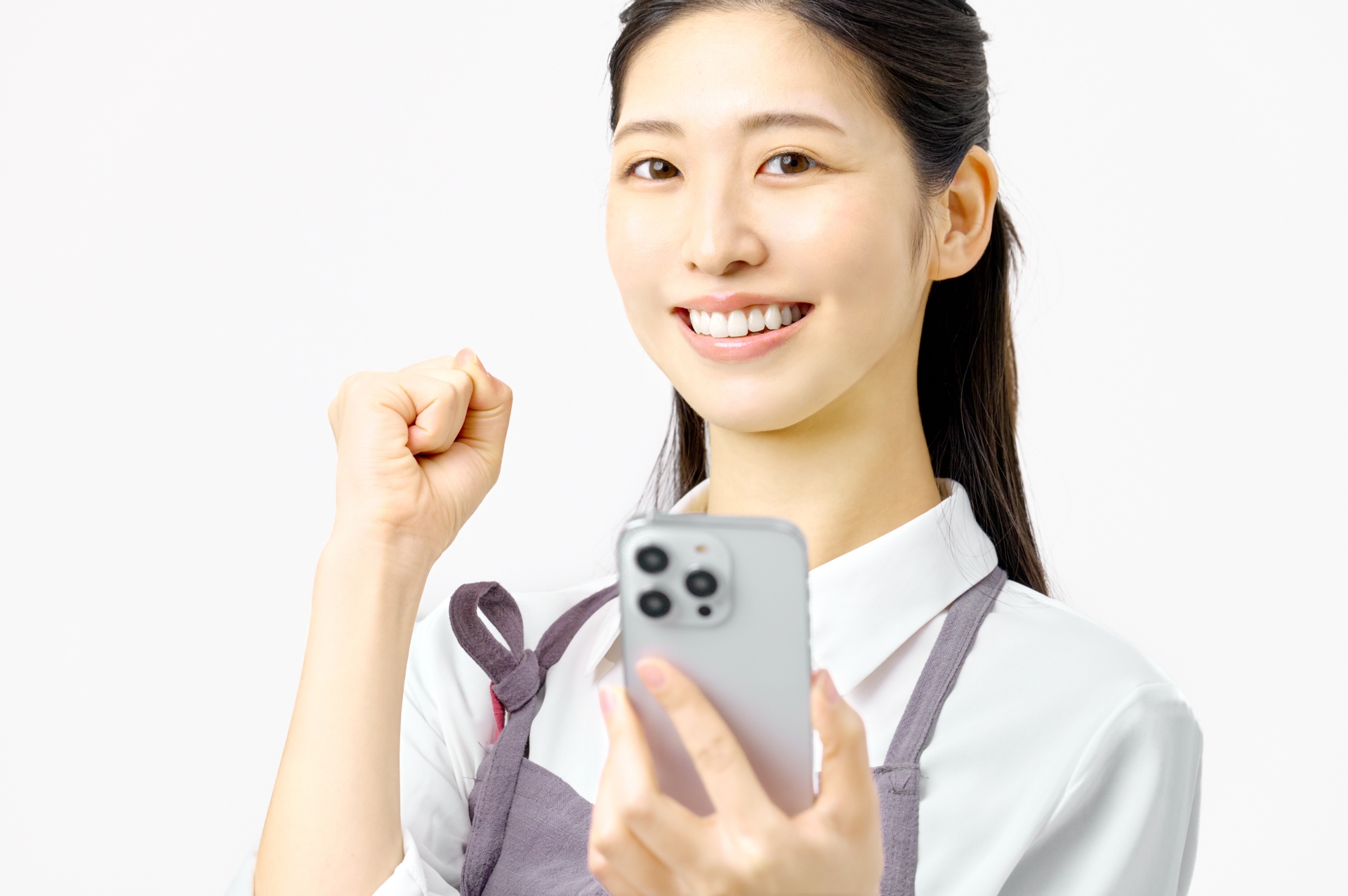 スマホを持ちガッツポーズする主婦