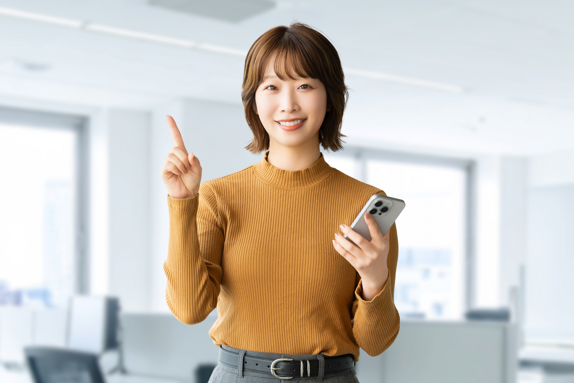 スマホを持って案内をする笑顔の女性