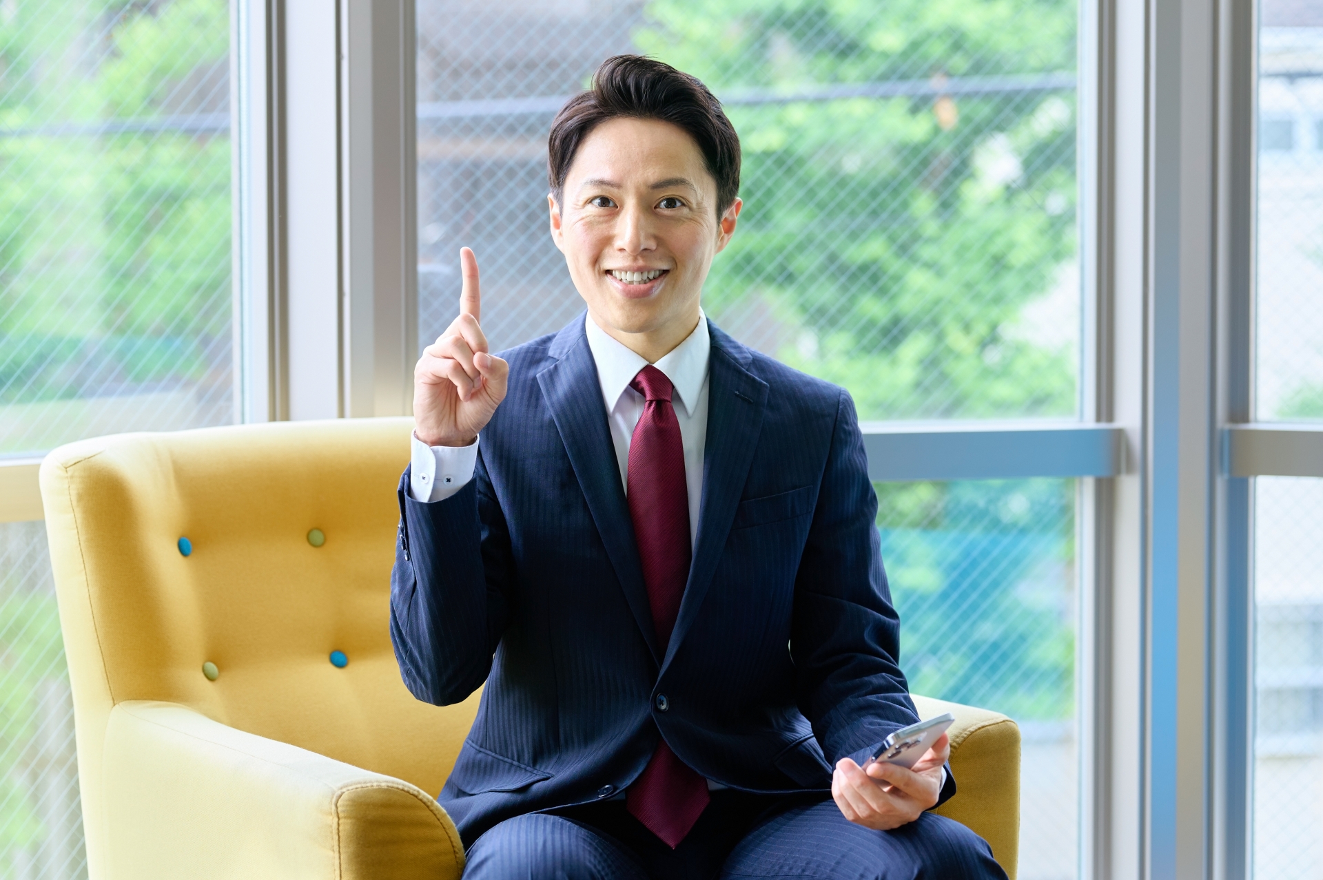 人差し指を立てて説明するビジネスマン