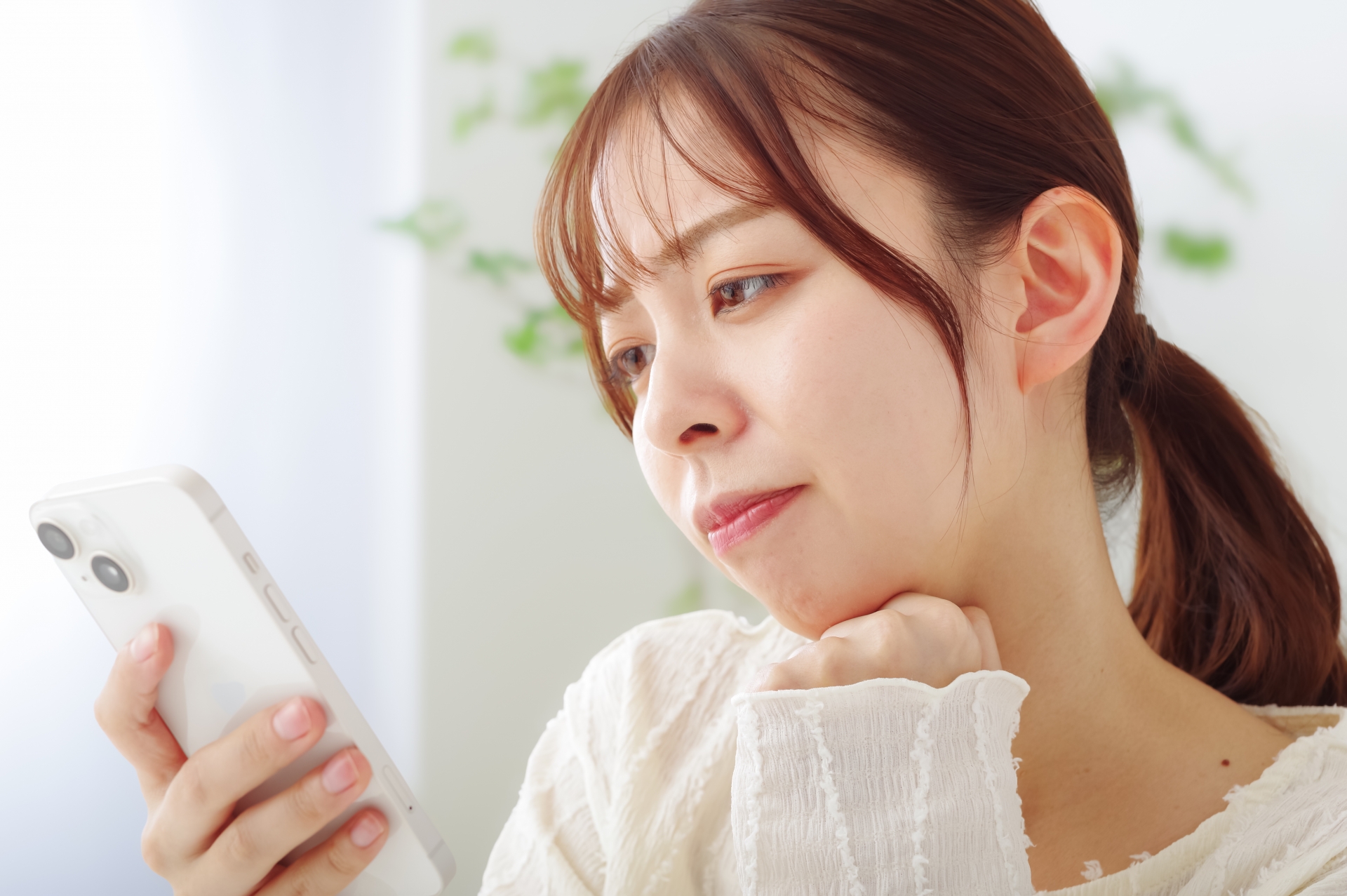 スマホを見て冴えない表情をする女性