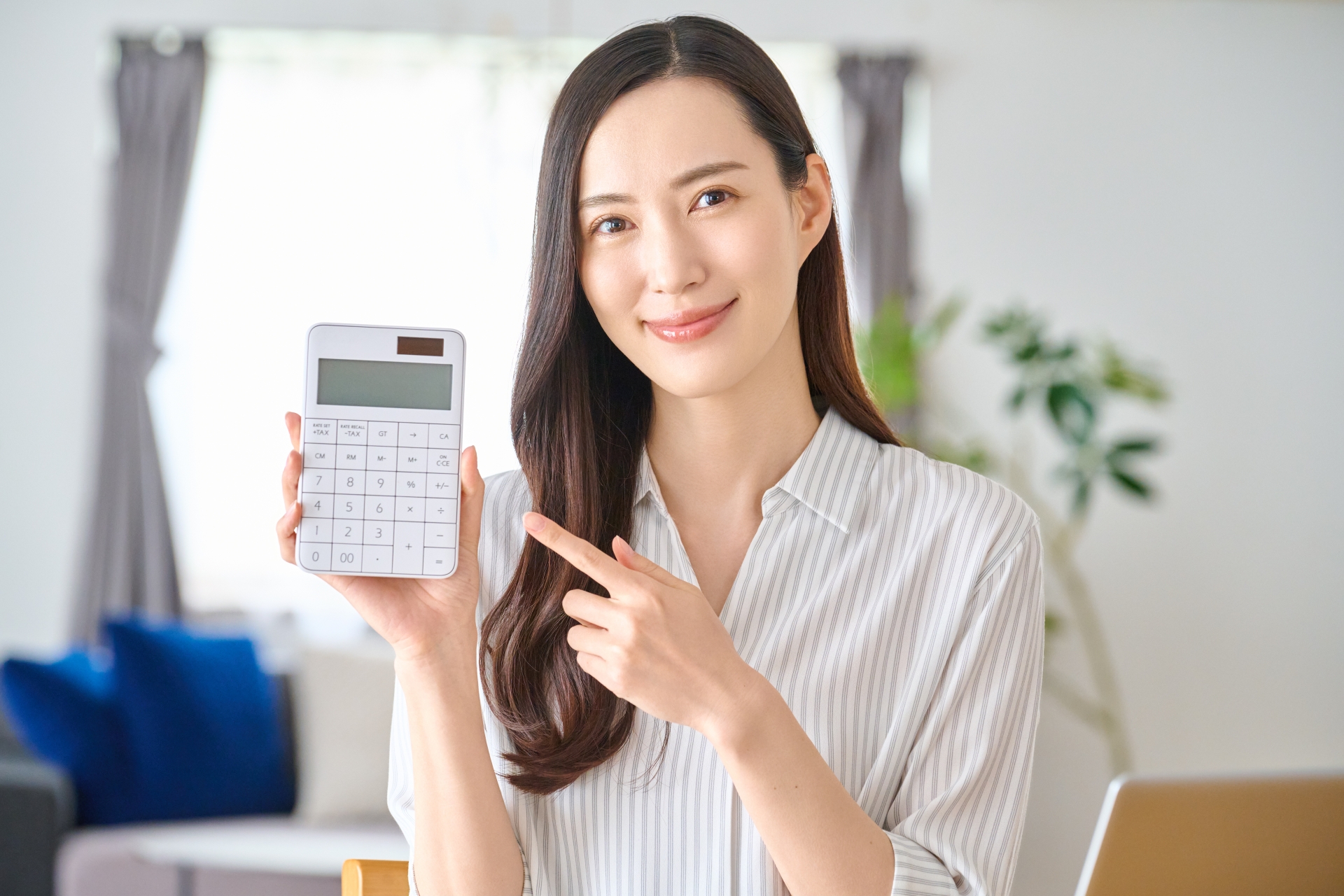 電卓を指さす笑顔の女性