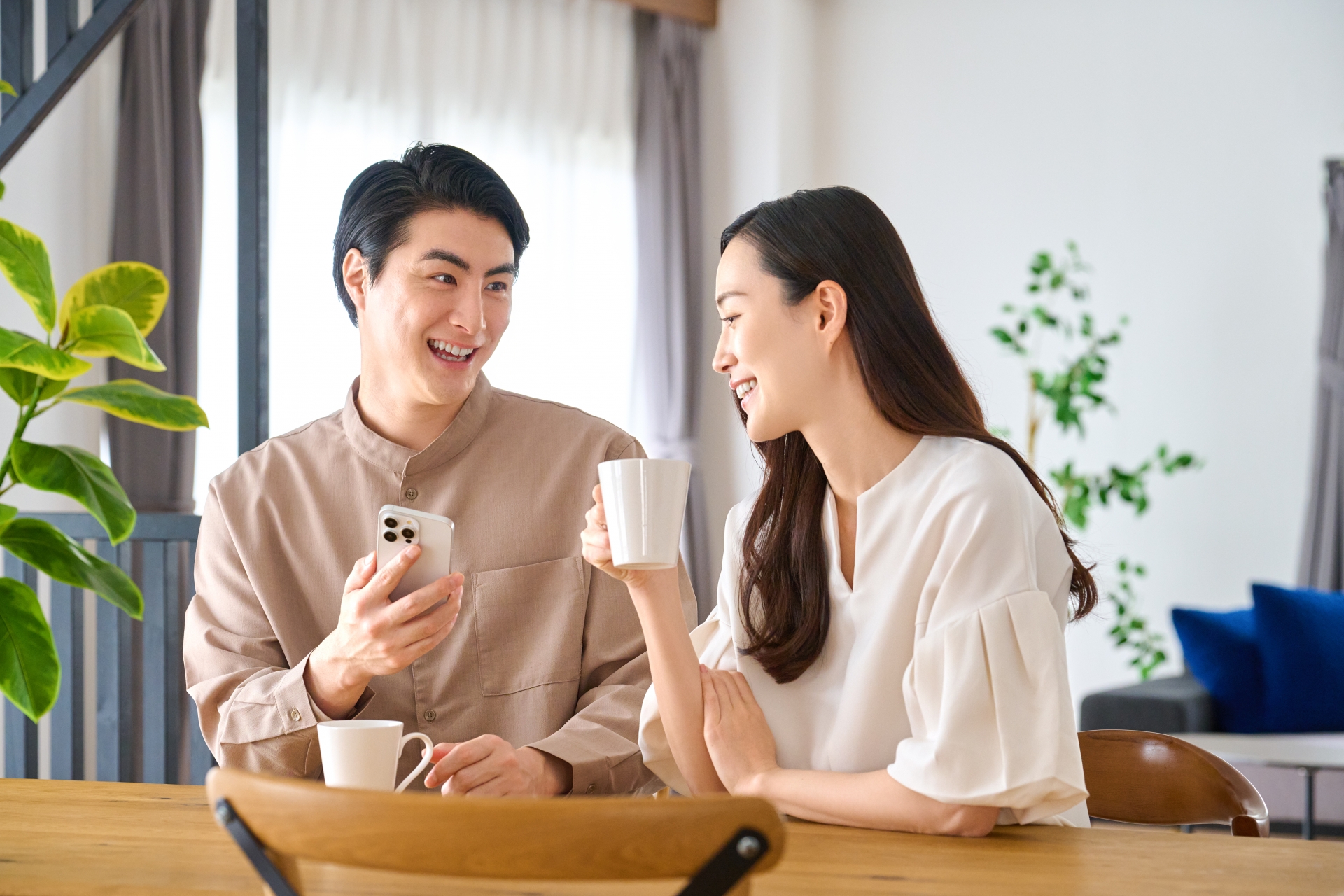 スマホを見ながら笑顔で話す夫婦