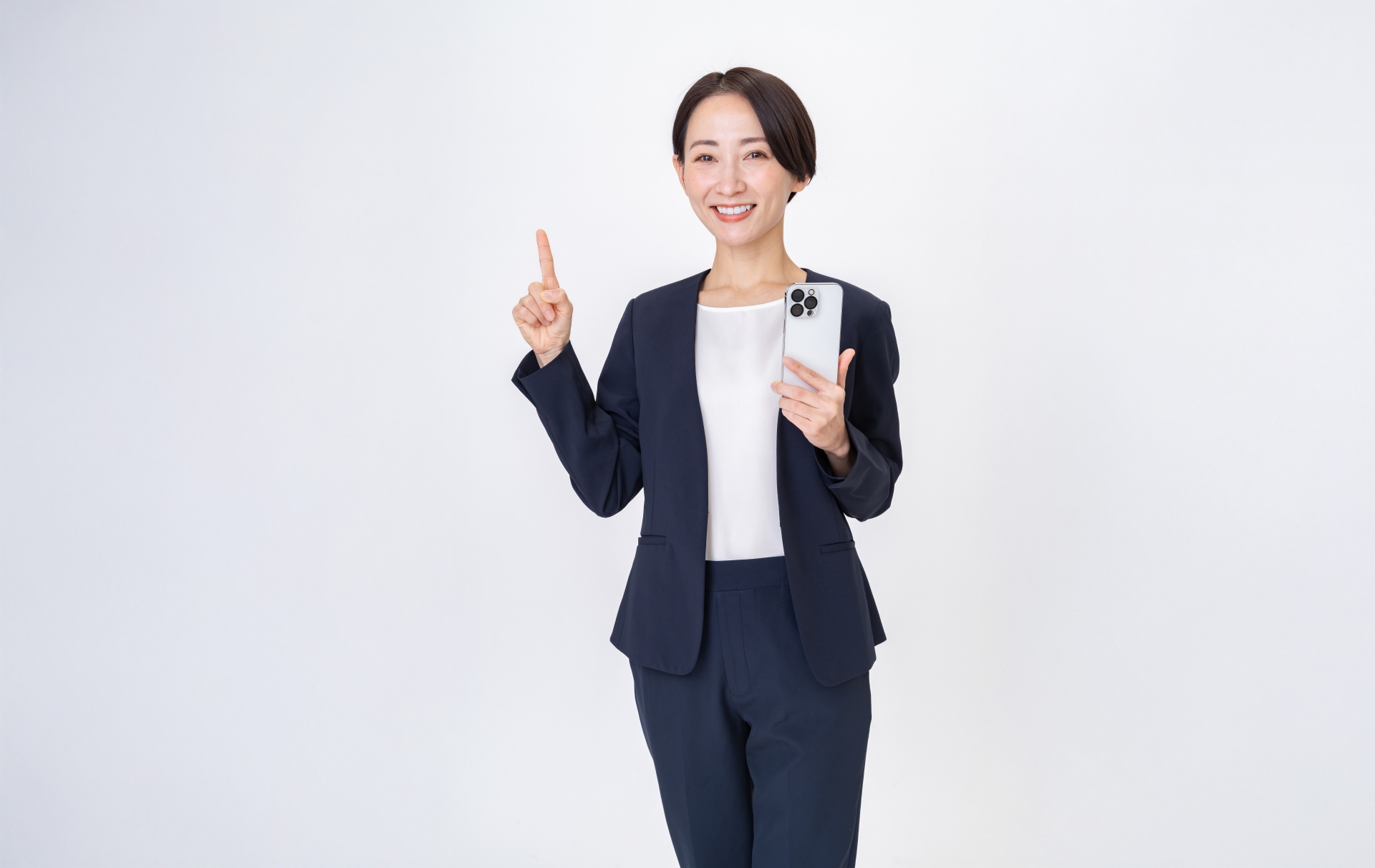 スマホを持ちつつ、人差し指を立てた女性
