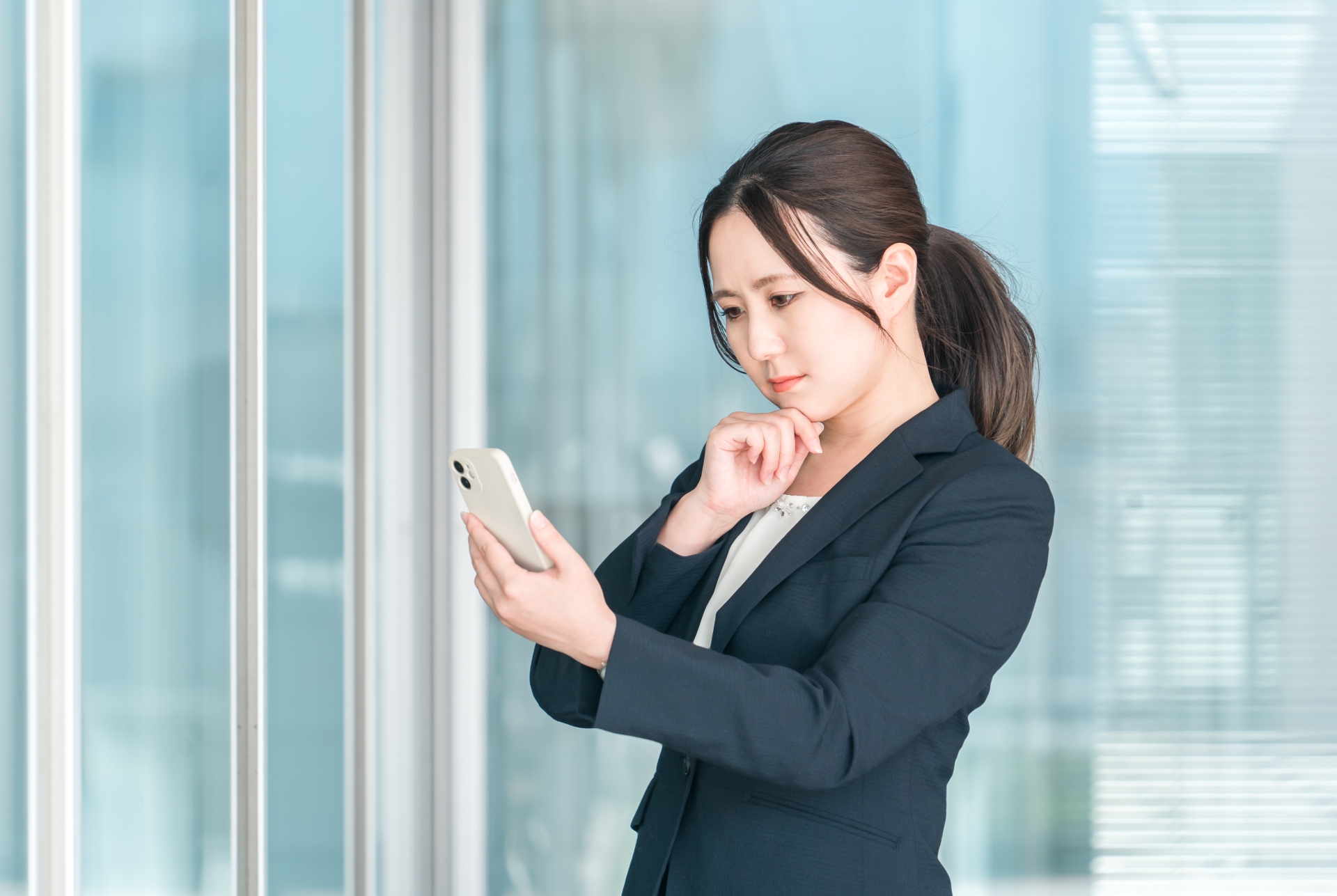 スマホを見て悩む女性