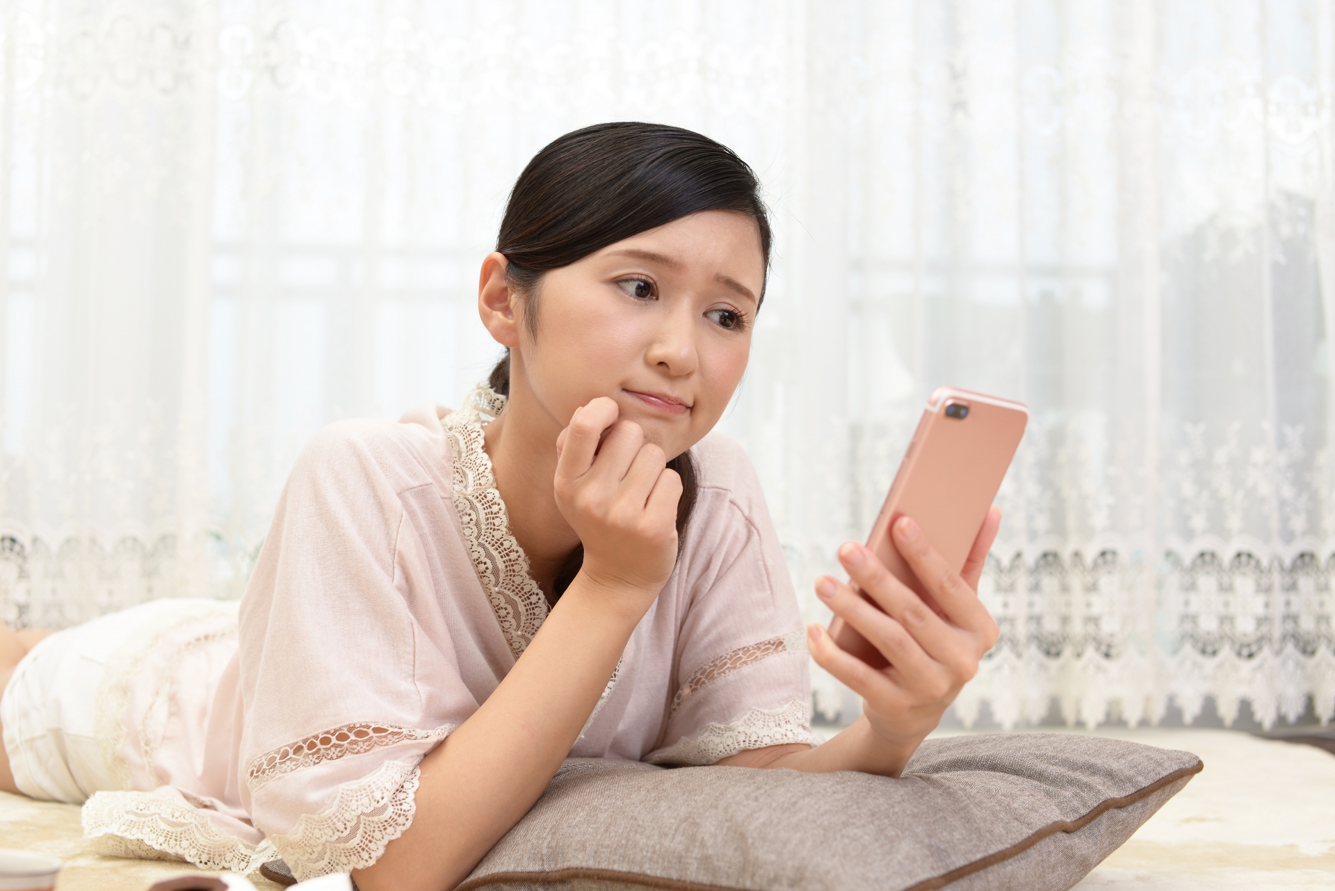 スマホを見て考える女性