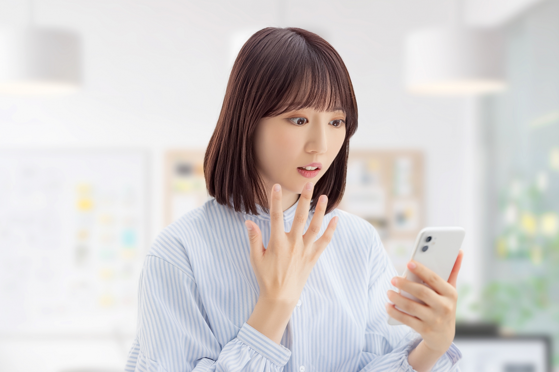 スマホを見て驚く女性